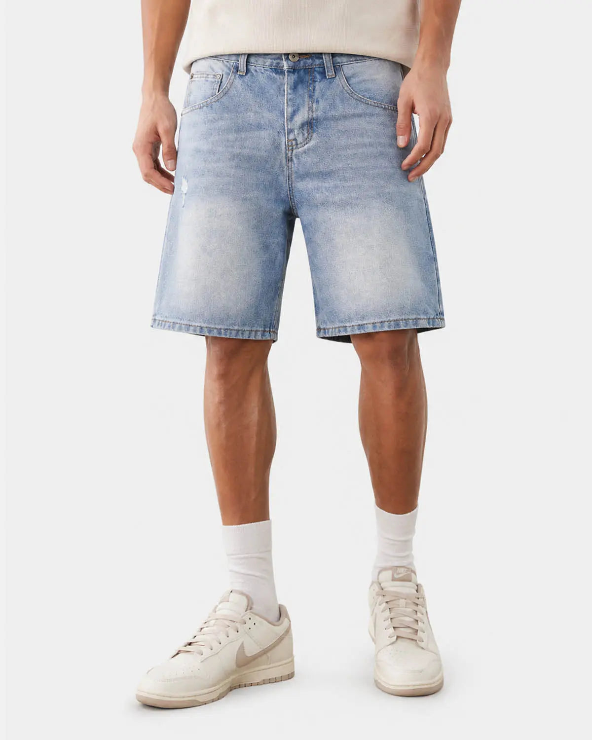 Ripped mid-length washed denim shorts by INFLATION, featuring distressed details and casual streetwear style.