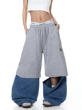 Denim detachable patchwork barrel joggers from Inflation Streetwear with distressed and patched design, relaxed fit, and cuffed ankles.