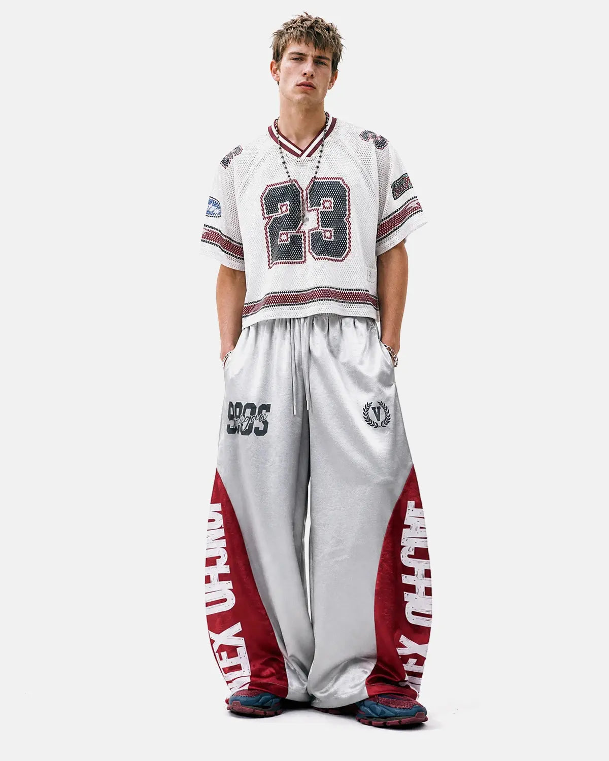 Model wearing glossy black contrast barrel sweatpants by INFLATION, featuring a relaxed fit and stylish streetwear design.