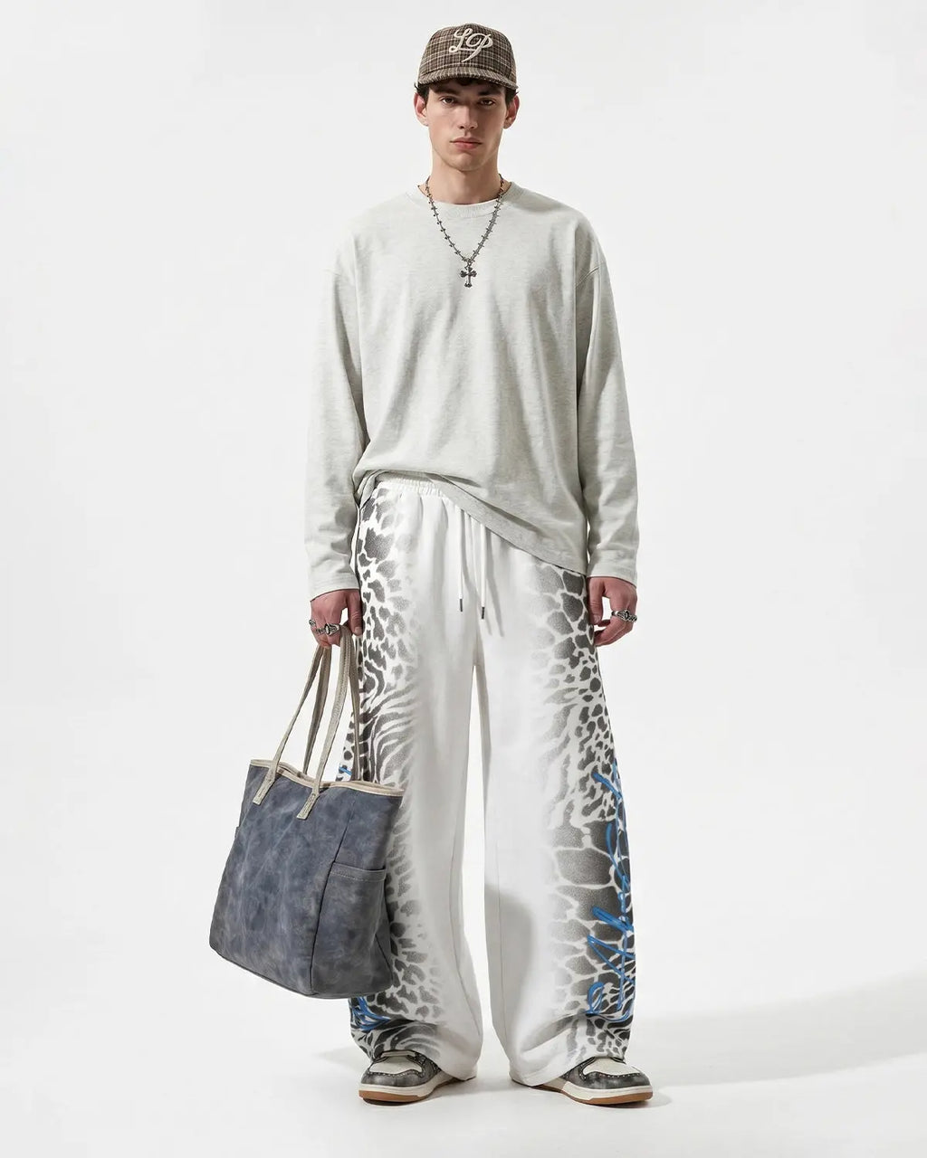 Leopard graphic design on black barrel sweatpants by INFLATION, streetwear style with relaxed fit and bold animal print.