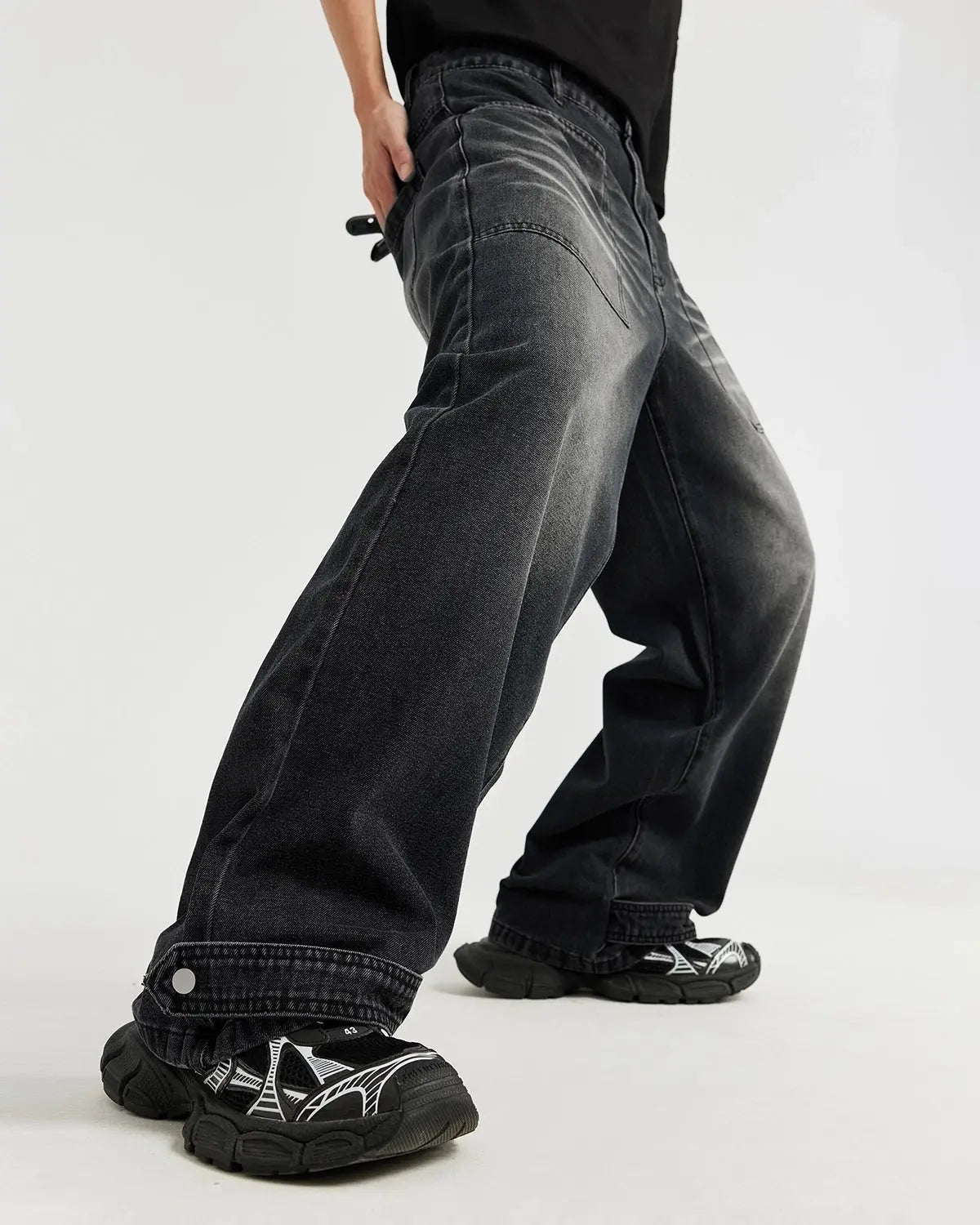 Black washed baggy jeans from Flation Streetwear with a relaxed fit and distressed details, displayed on a hanger.