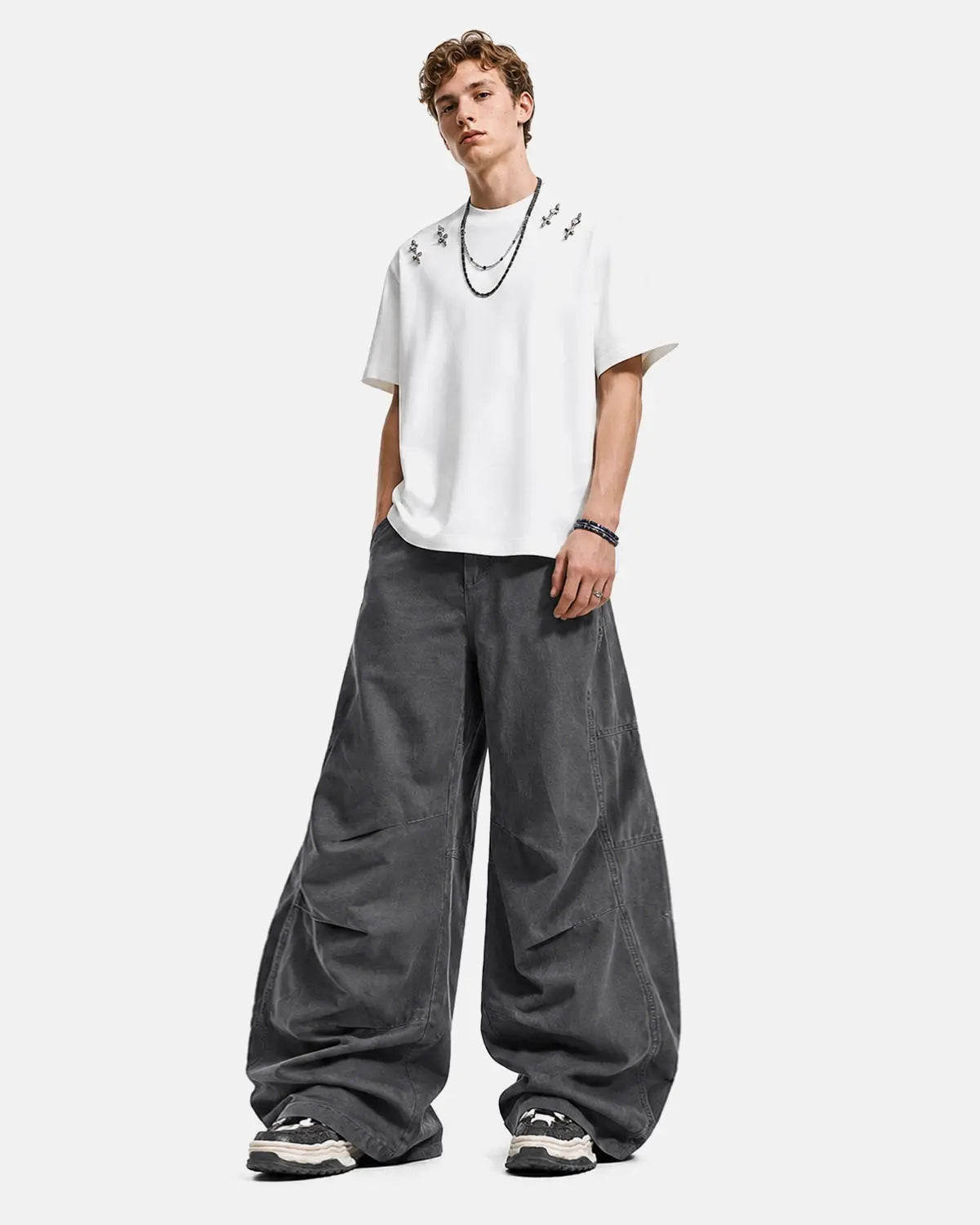 Dark washed curved seam cargo pants by INFLATION featuring relaxed fit and multiple pockets, streetwear style, front and side view.