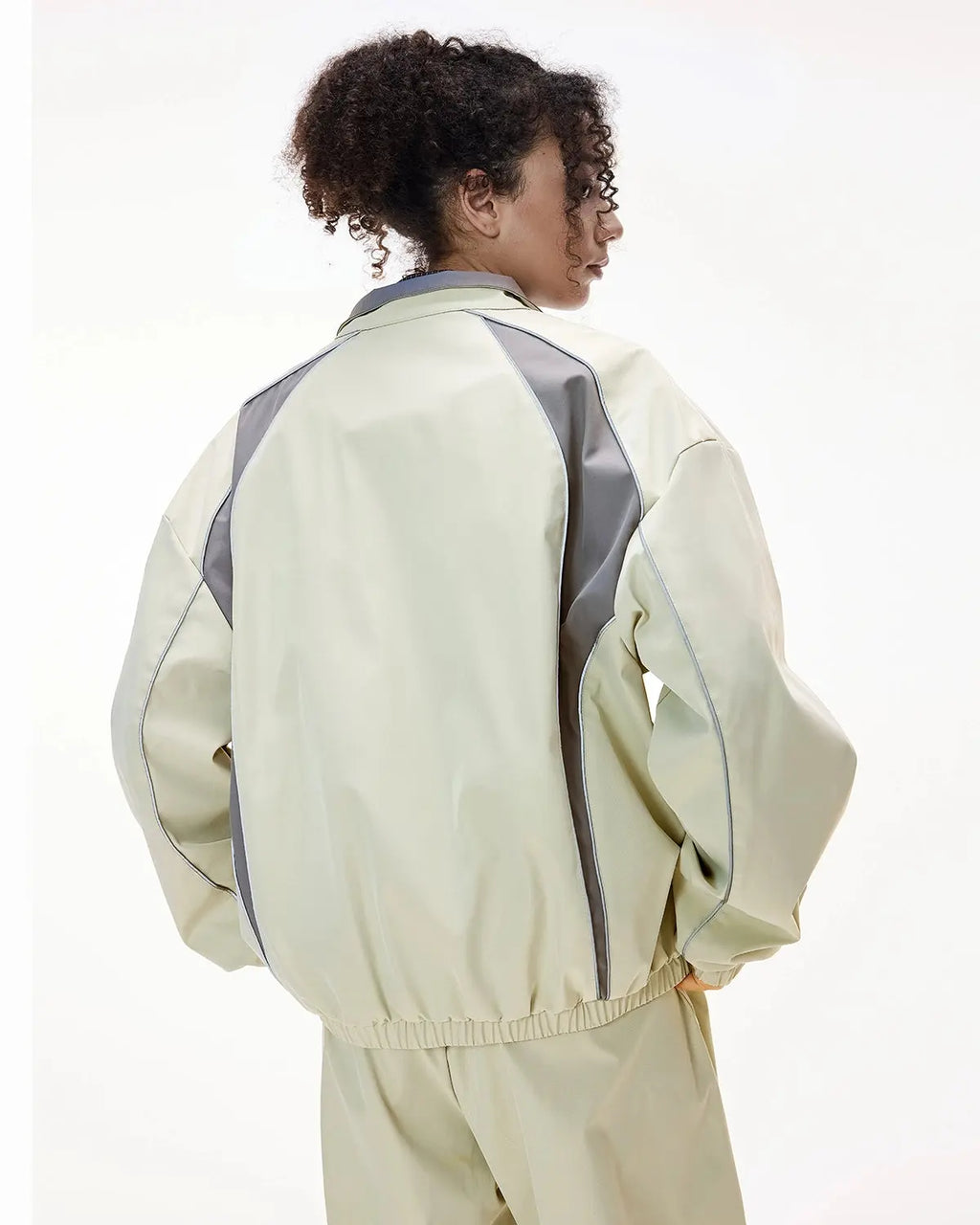 Reflective Flation streetwear windbreaker track jacket with metallic accents, featuring a lightweight design and adjustable hood.