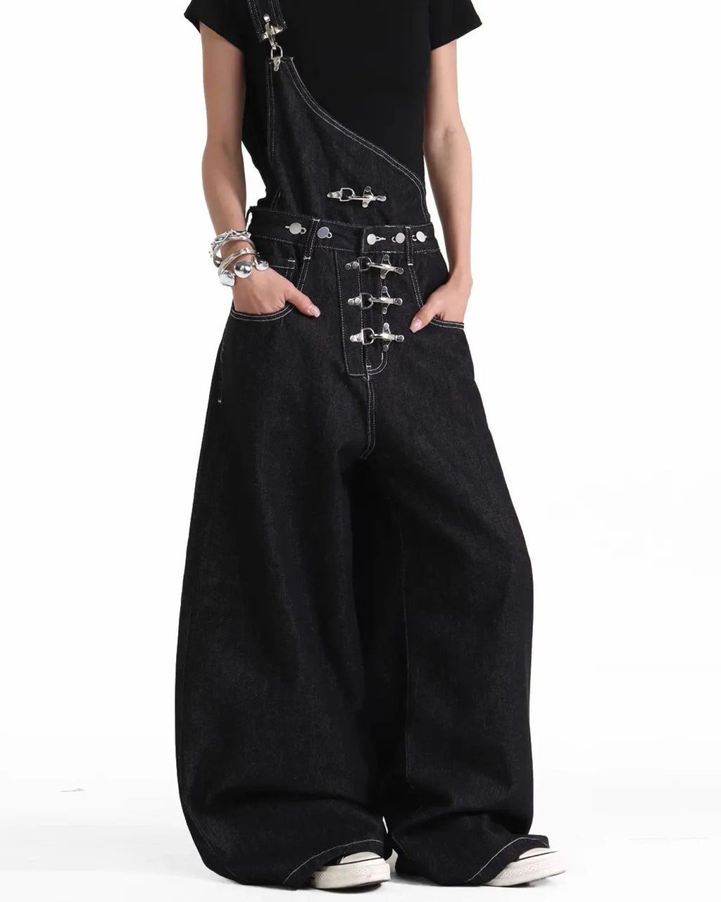 Asymmetric buckle denim overalls jeans by INFLATION featuring unique design, front pockets, and adjustable straps.