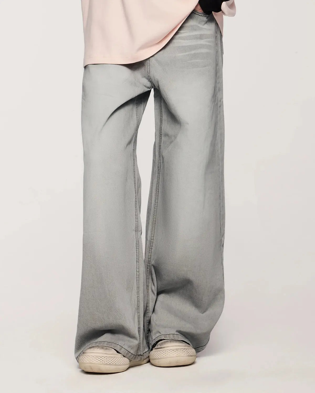 Washed distressed baggy jeans by Flation Streetwear, featuring a relaxed fit, ripped details, and faded denim texture.