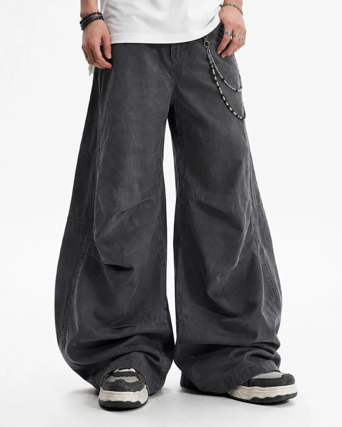 Washed curved seam cargo pants by INFLATION featuring a relaxed fit, multiple pockets, and distressed denim texture.