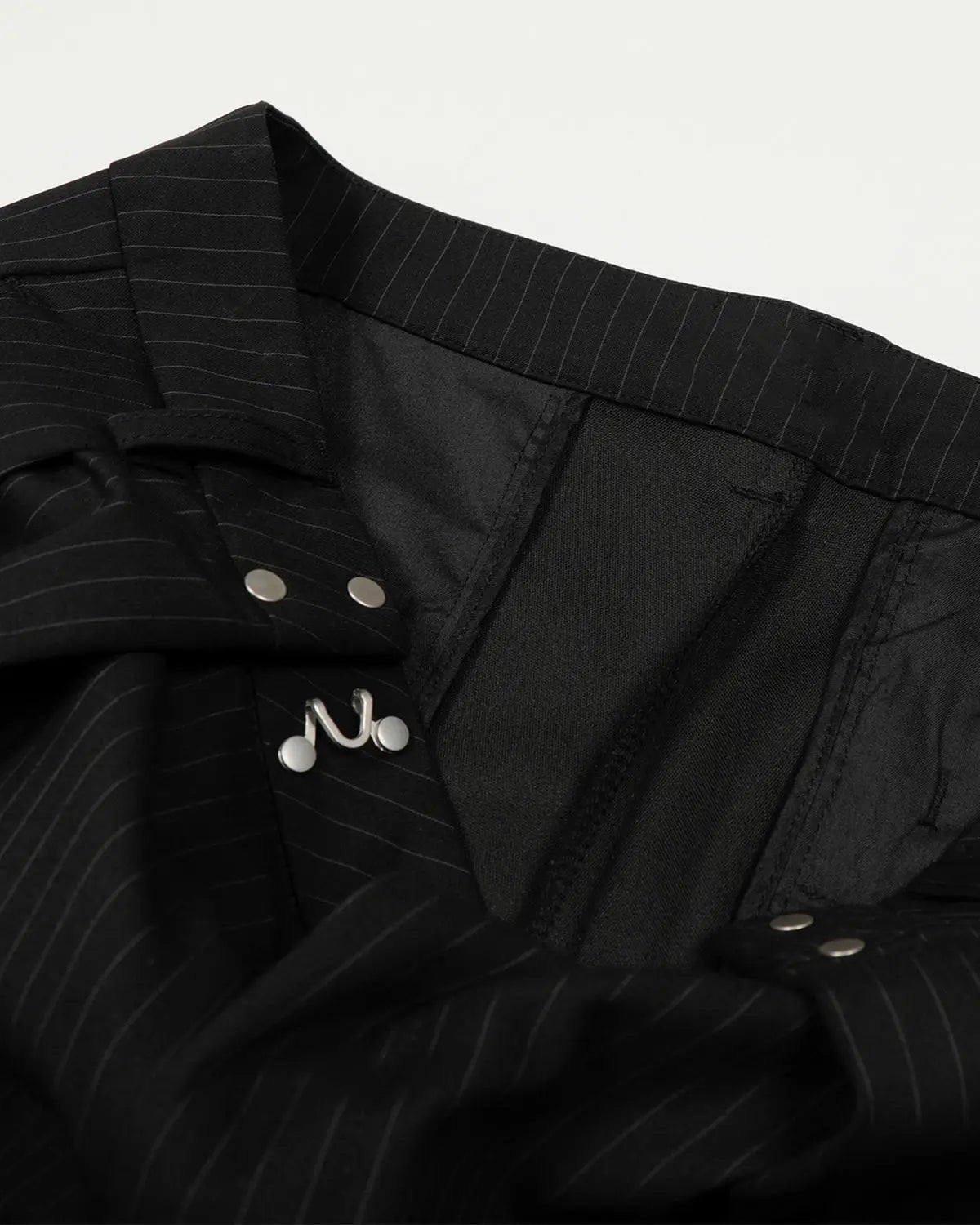 Black striped barrel suit pants by INFLATION, featuring a relaxed fit and stylish streetwear design, shown on a model.