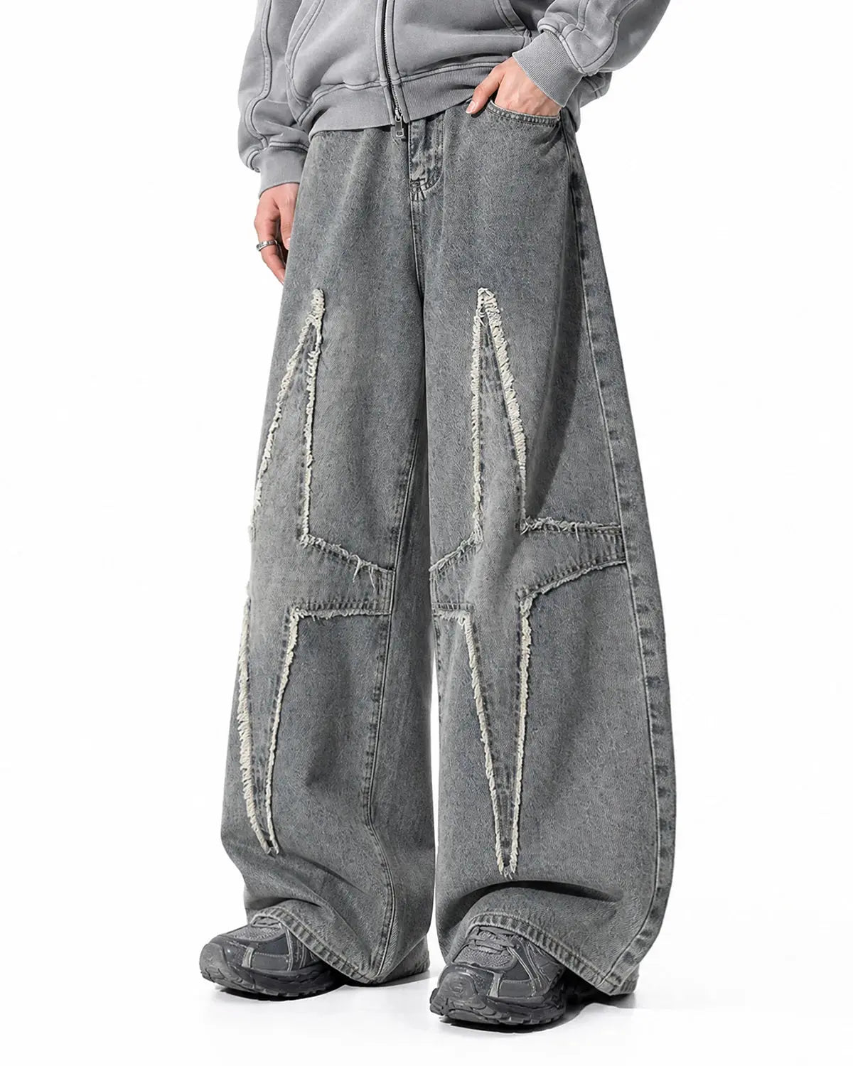 Star patched baggy jeans by INFLATION Streetwear with distressed details and relaxed fit, shown on a model.