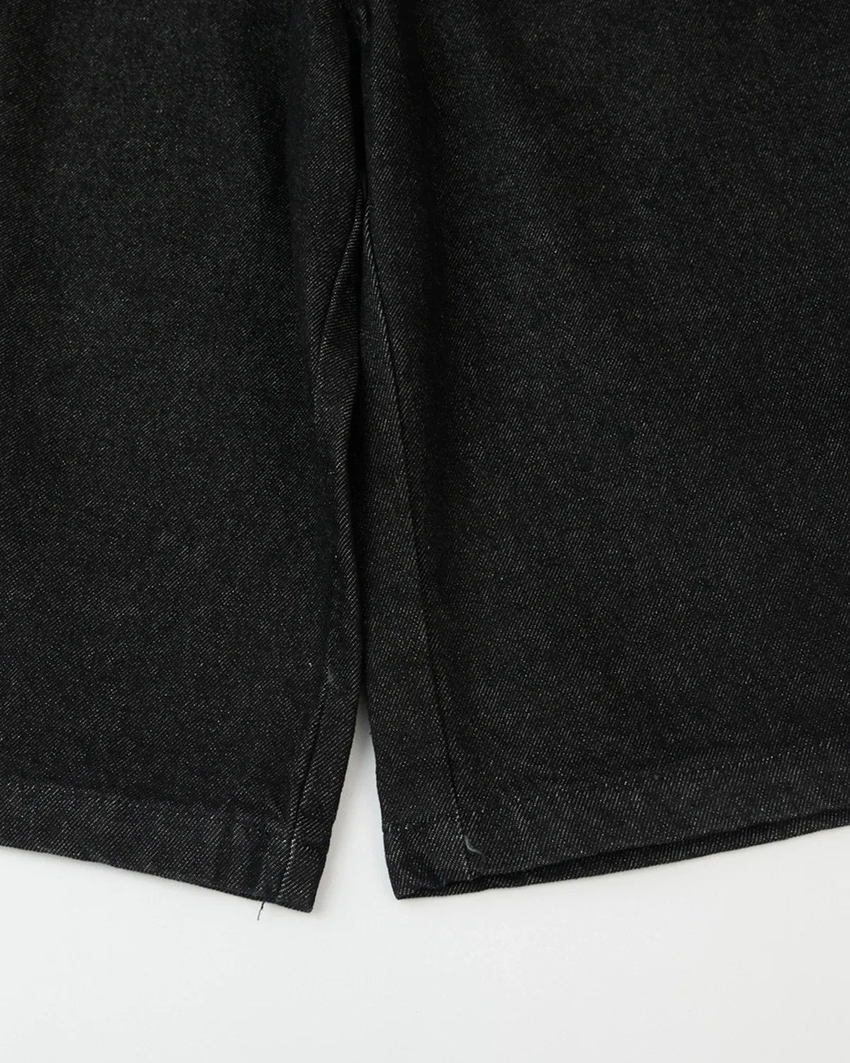 Black baggy long jorts from INFLATION streetwear, featuring oversized denim shorts with a relaxed fit and cuffed hems.