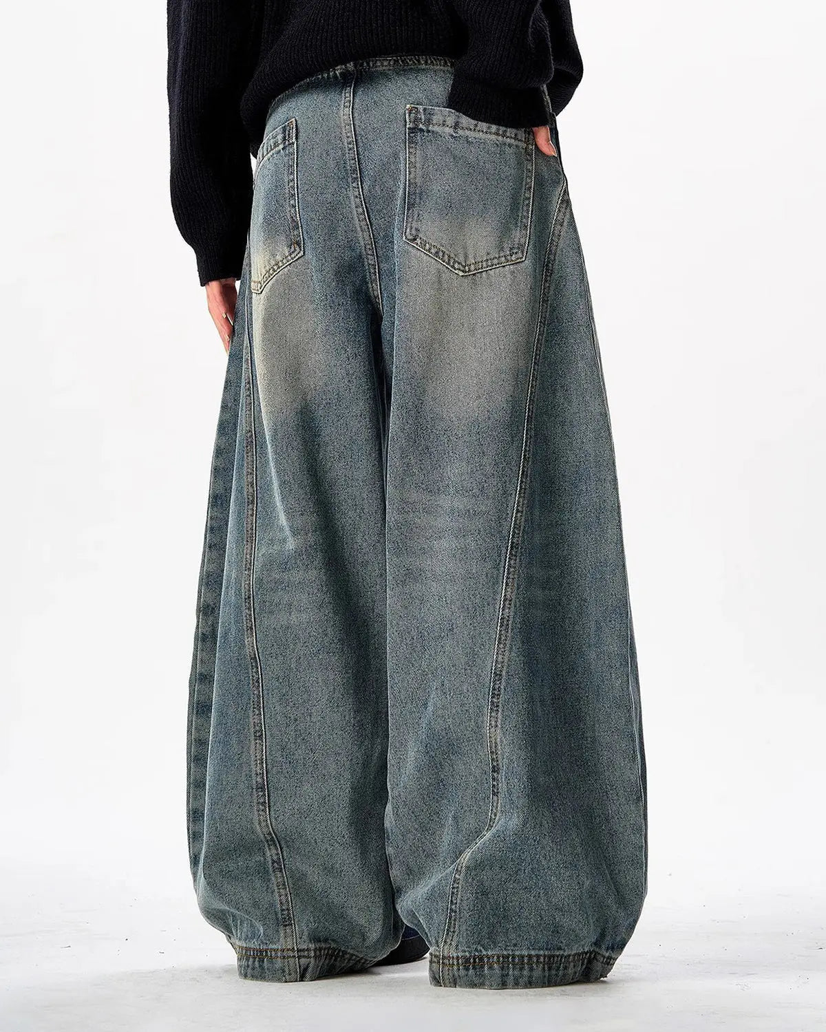 Vintage washed barrel jeans by INFLATION featuring a relaxed fit and faded denim, styled with visible pocket details and belt loops.