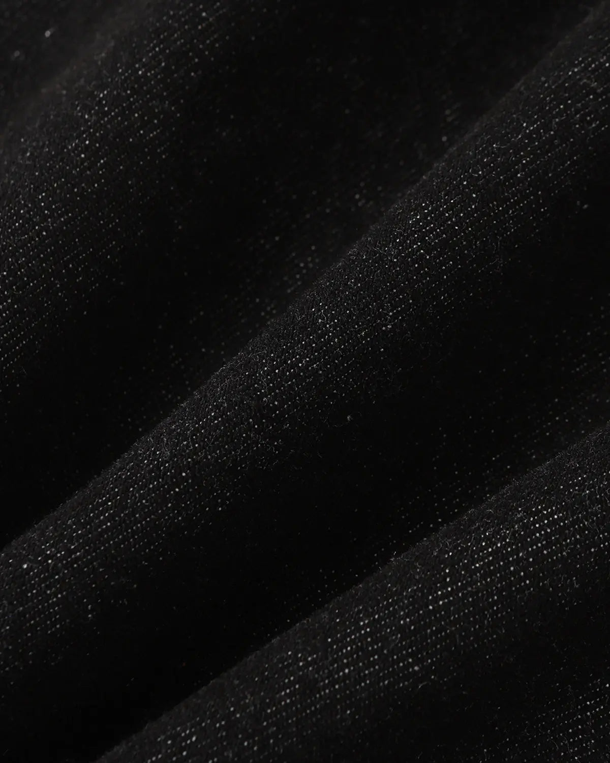 Deconstructed raw bootcut jeans by INFLATION with visible stitching details and raw hem, showcasing a relaxed streetwear style.