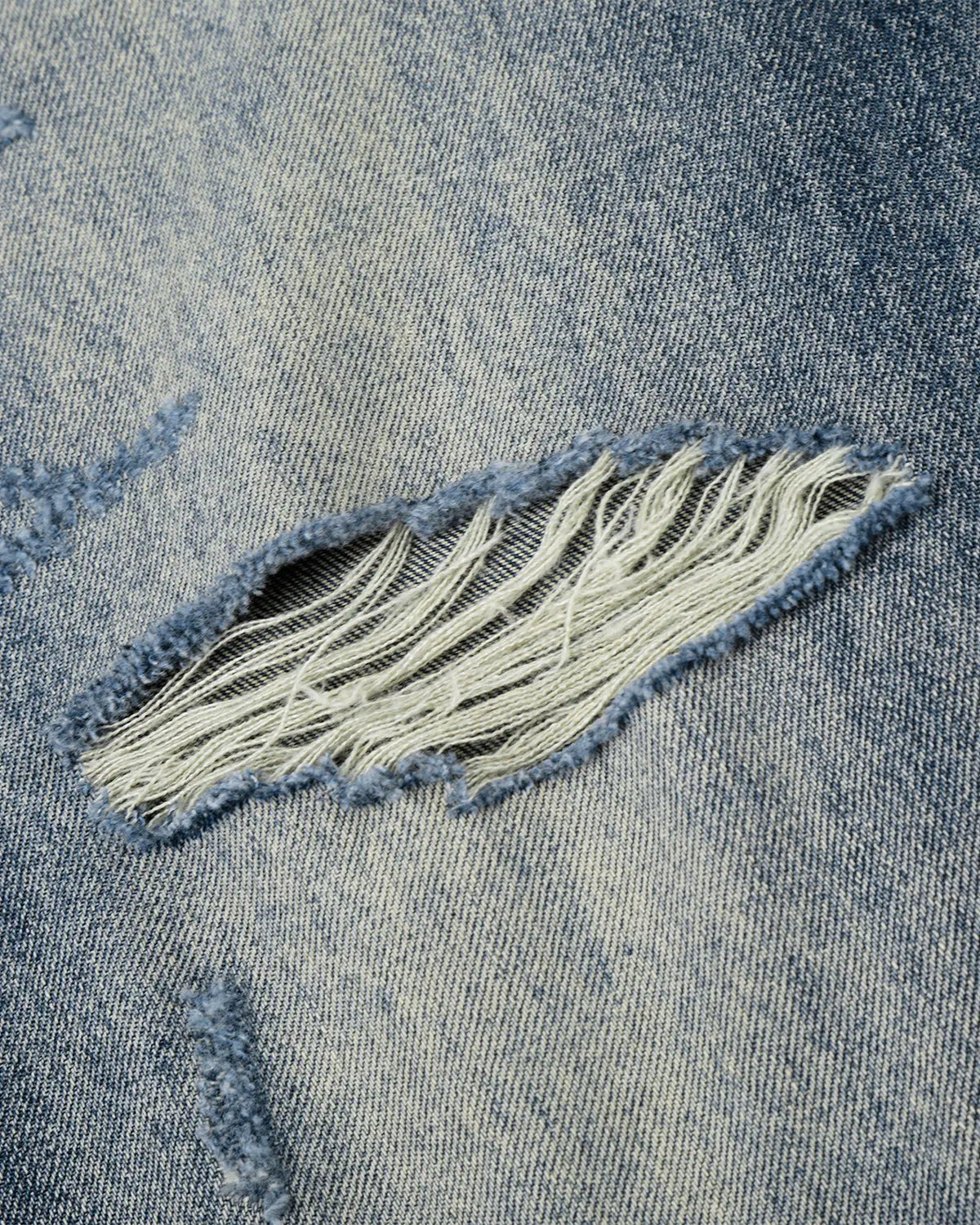 Inflation Whisker Wash distressed baggy jeans with a relaxed fit, featuring faded details and a casual streetwear style.