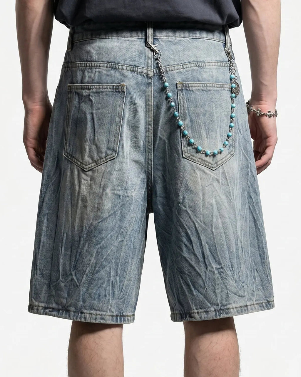 Textured washed longline jorts by INFLATION, denim-style pants with a relaxed fit and distressed details, displayed on a model.