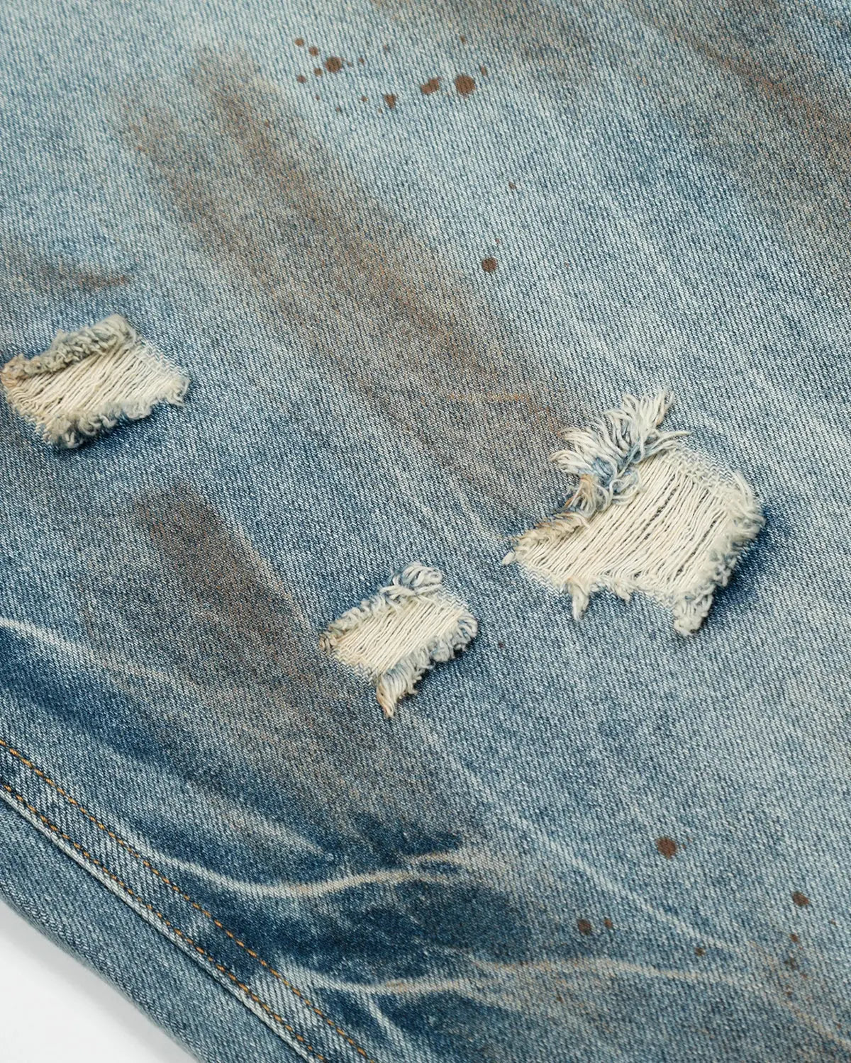 Distressed barrel jeans by INFLATION with a washed, vintage look, featuring rips and fading for a rugged streetwear style.