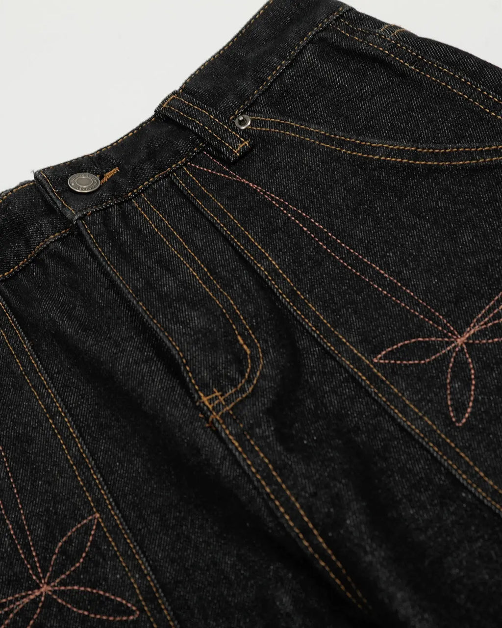 Raw embroidery Baggy Jeans by INFLATION, streetwear denim with distressed details and relaxed fit, shown in a close-up view.