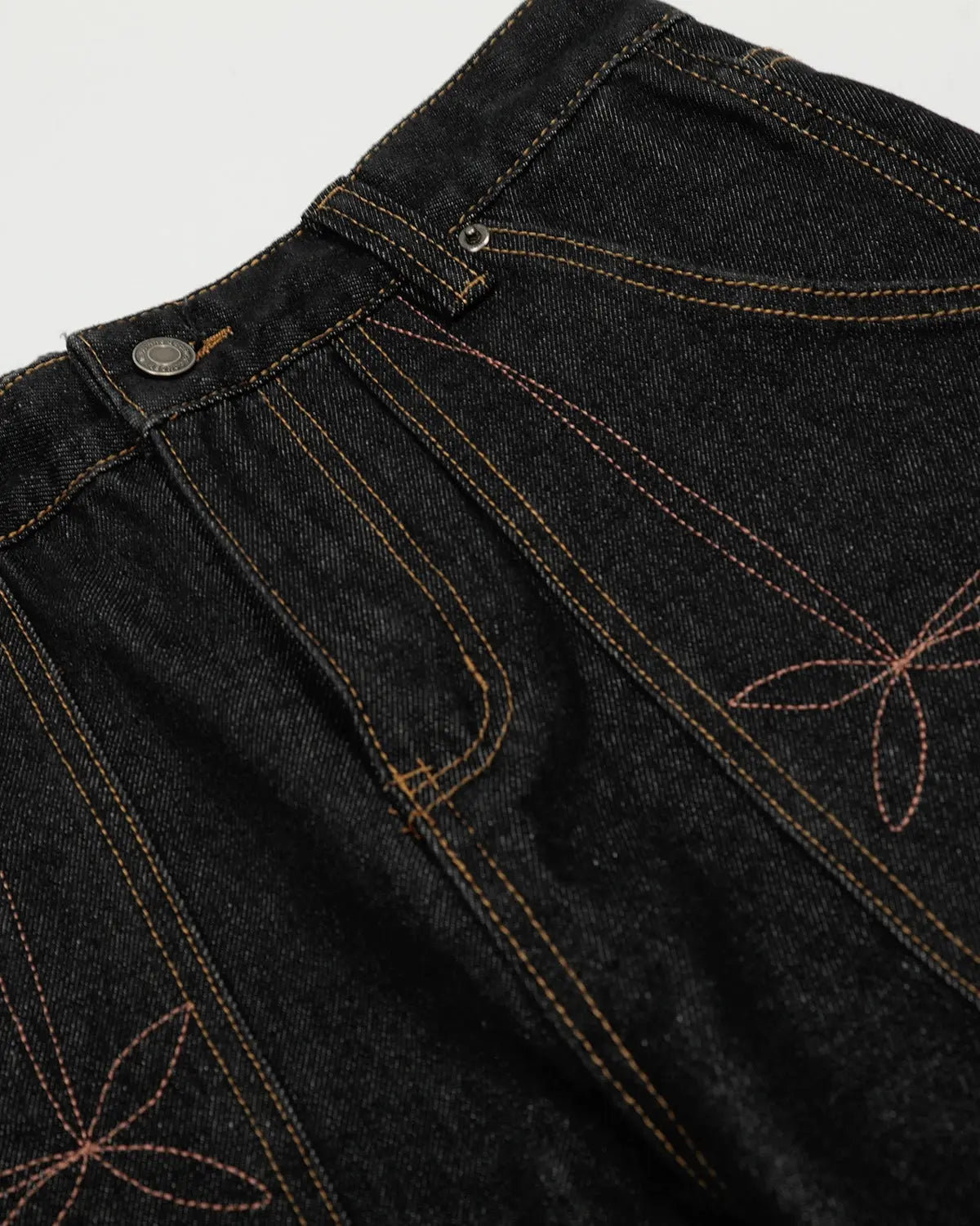 Raw embroidery Baggy Jeans by INFLATION, streetwear denim with distressed details and relaxed fit, shown in a close-up view.