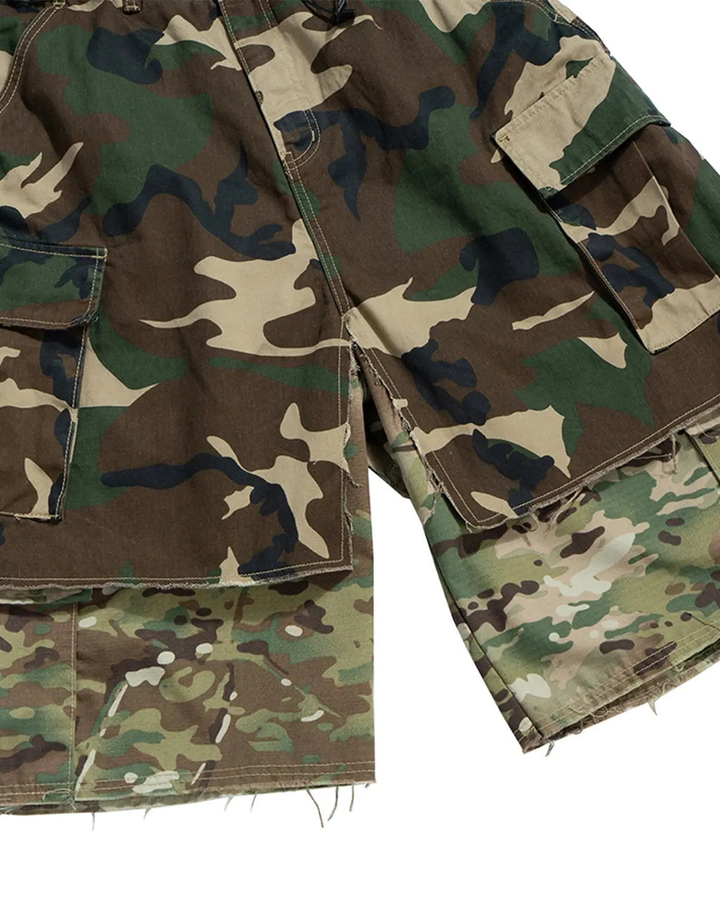 Camo layered longline jorts from INFLATION streetwear with a relaxed fit and distressed hem, showcasing urban casual style.