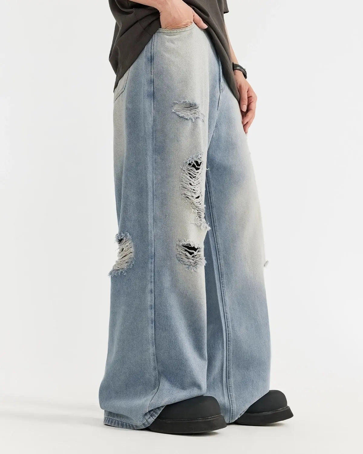 Distressed ripped blue jeans by INFLATION Streetwear, featuring frayed hems and torn knee details on casual denim pants.