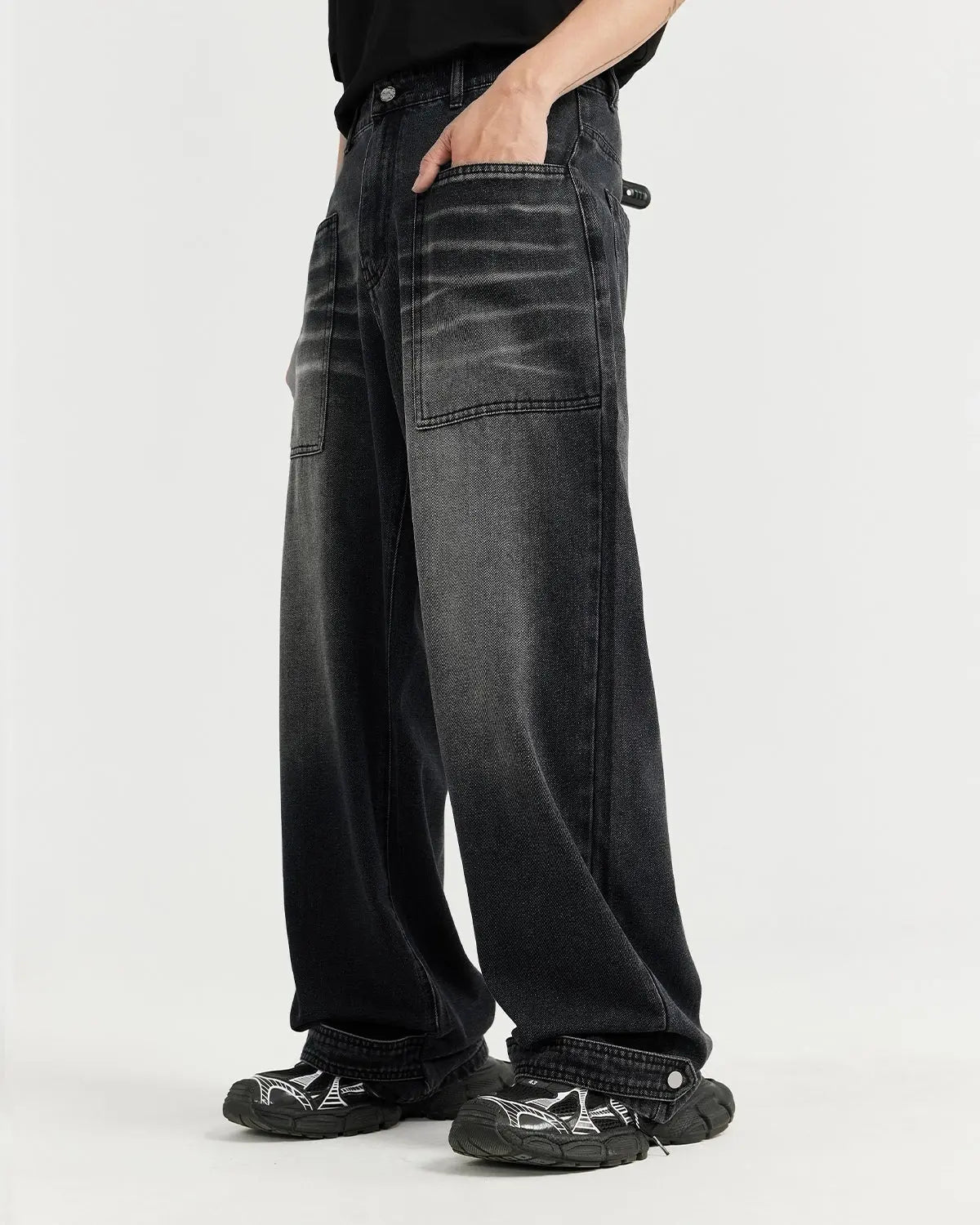 Black washed baggy jeans by Flation Streetwear with a relaxed fit and distressed details, displayed on a hangar.
