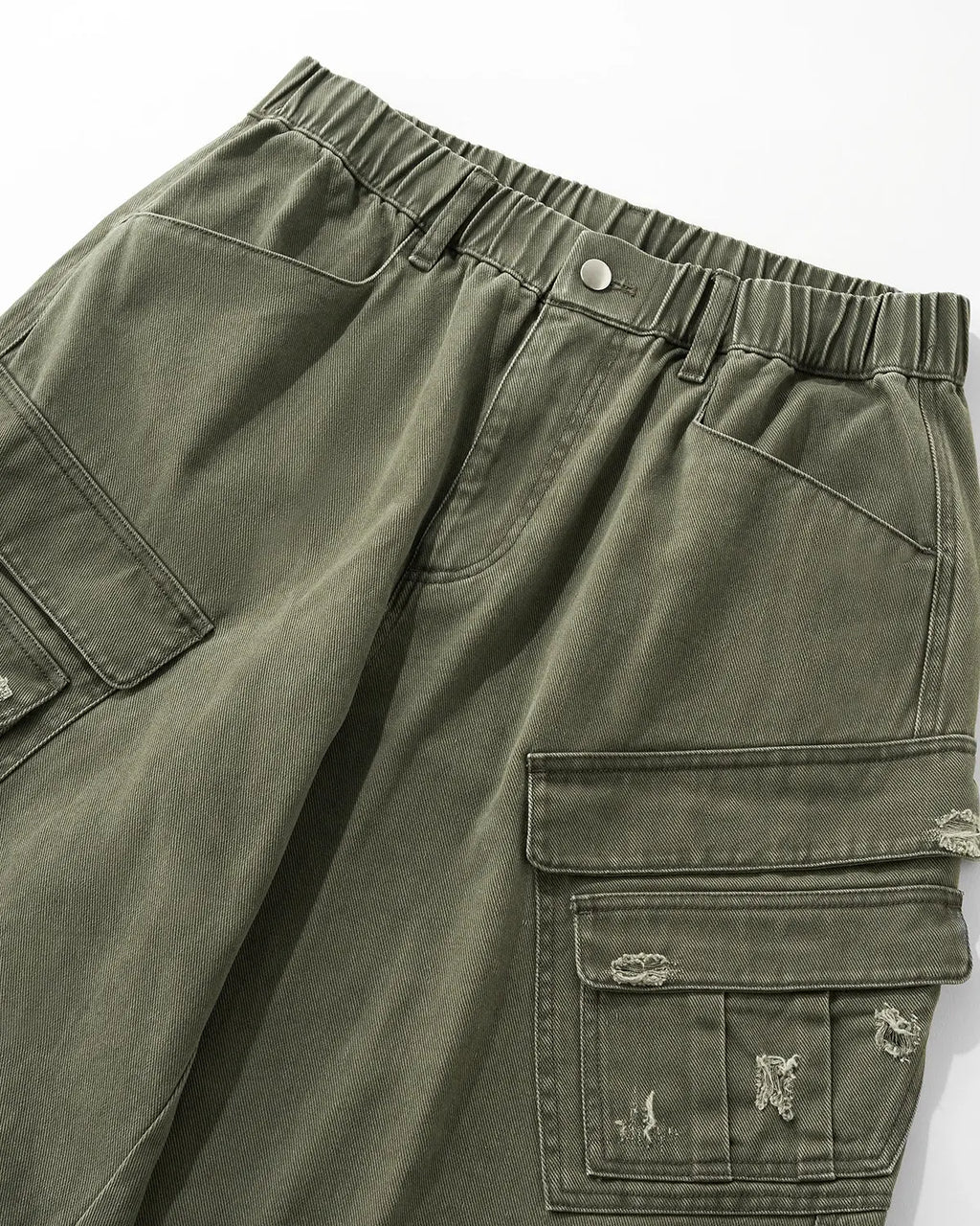 Inflation brand ripped cargo pants with distressed details and multiple pockets, styled as streetwear fashion.