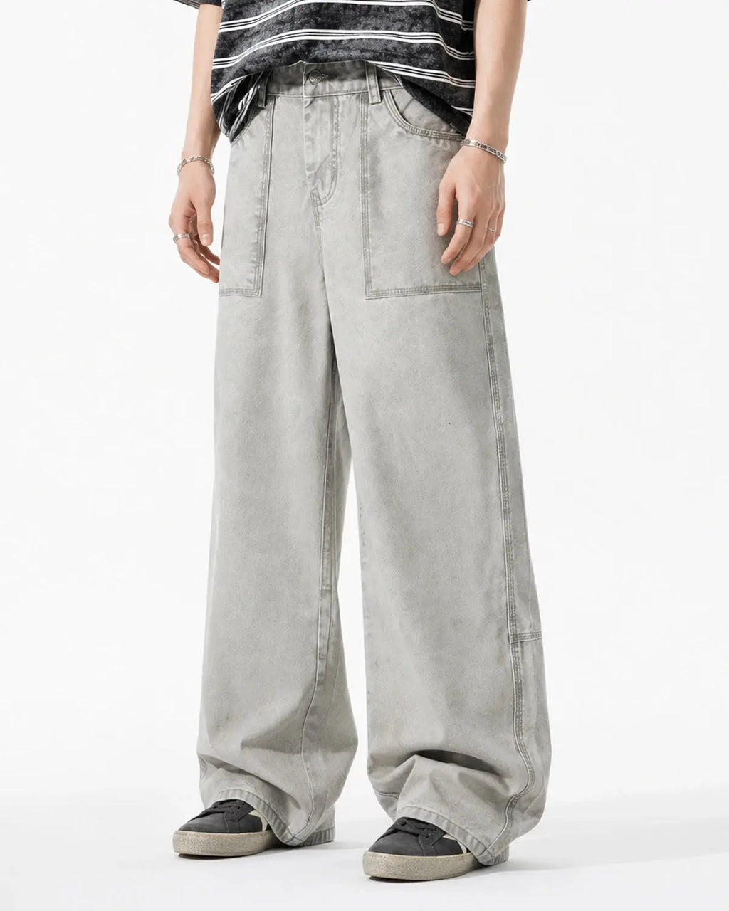 Deconstructed distressed barrel jeans by INFLATION Streetwear, showing ripped fabric and relaxed fit on model.