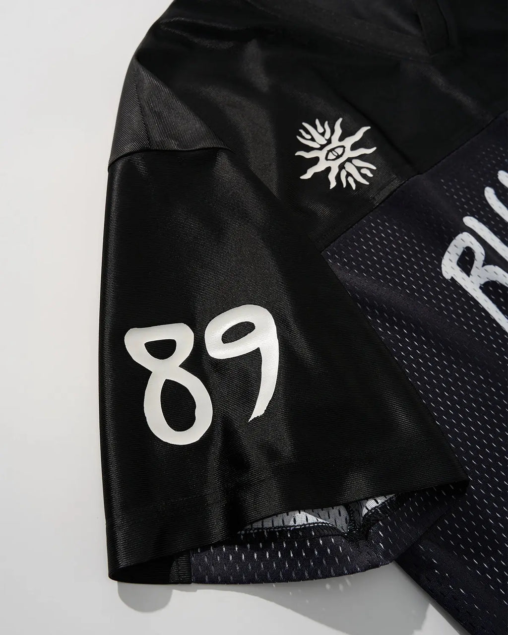 V-neck mesh patchwork jersey tee by INFLATION, featuring breathable fabric and stylish streetwear design.