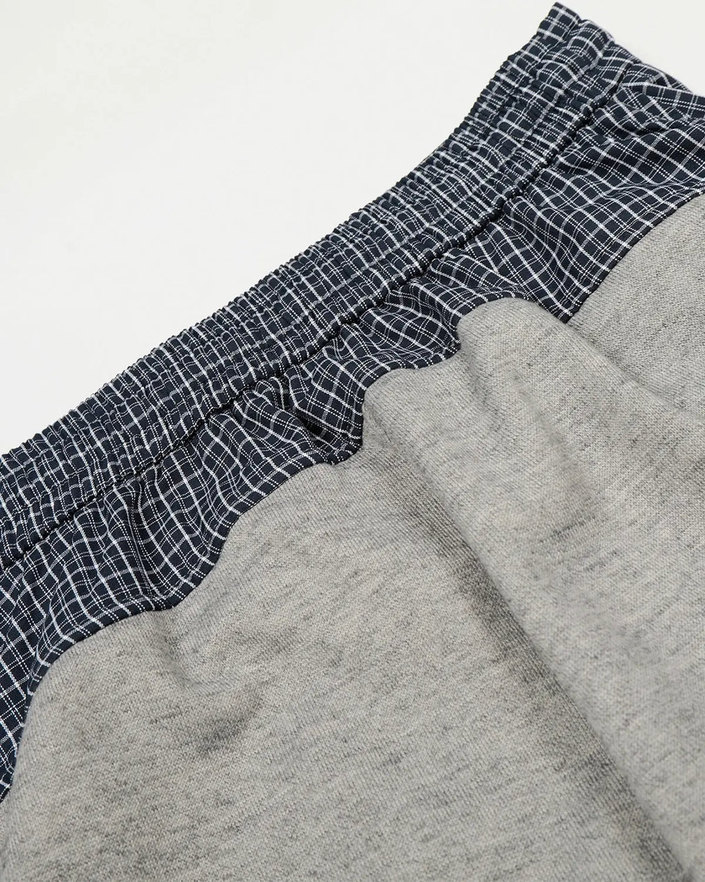 Plaid layered baggy sweatpants by INFLATION, featuring a relaxed fit and stylish plaid pattern for streetwear fashion.