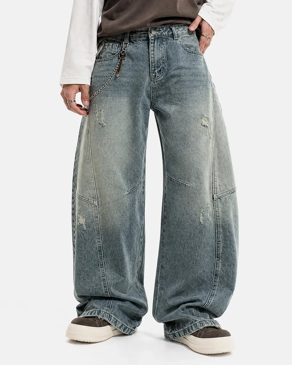 Acid washed distressed barrel jeans by INFLATION featuring a relaxed fit, frayed details, and vintage-inspired streetwear style.