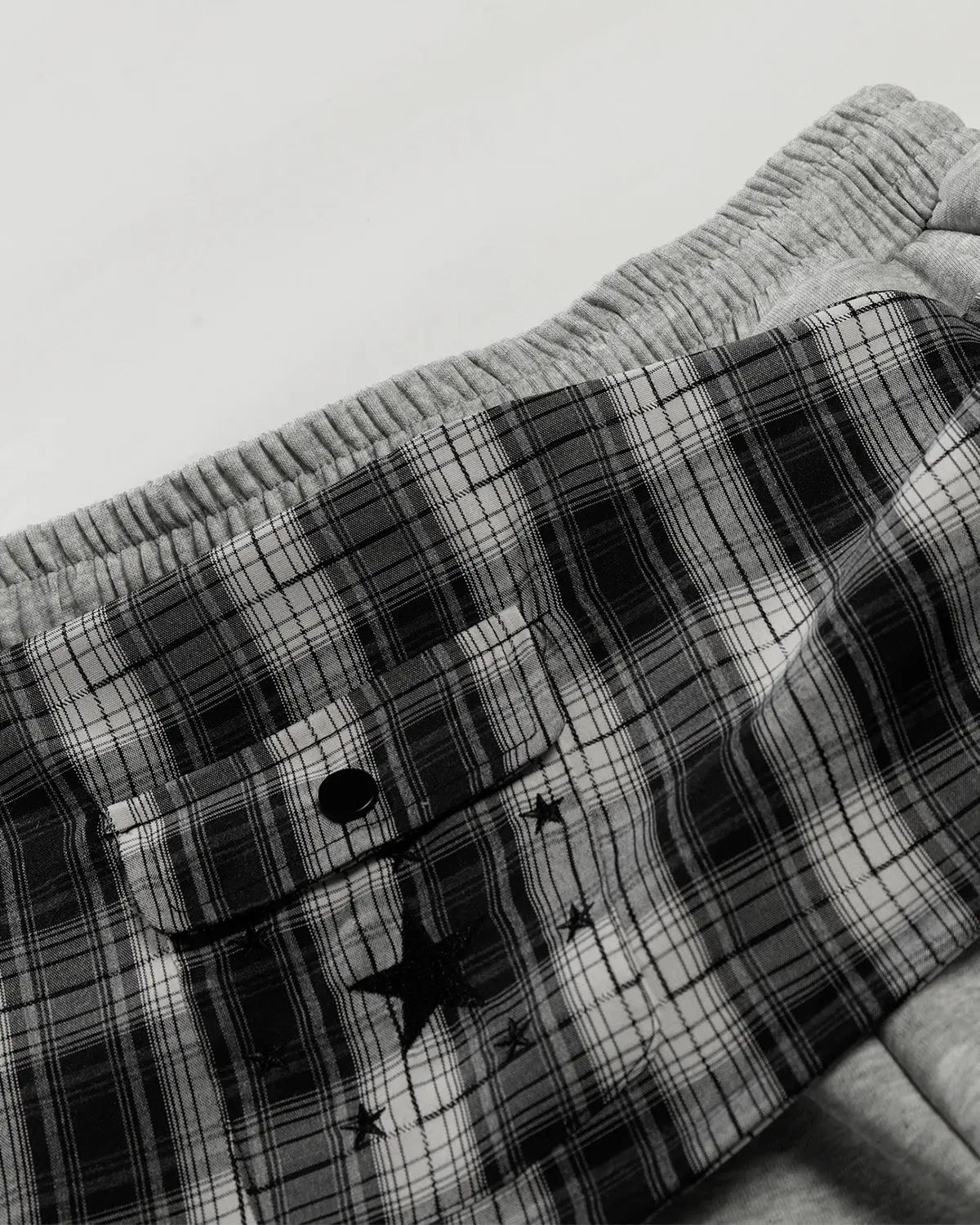 Plaid layered baggy sweatpants by INFLATION, featuring a relaxed fit and streetwear style with a layered plaid design.