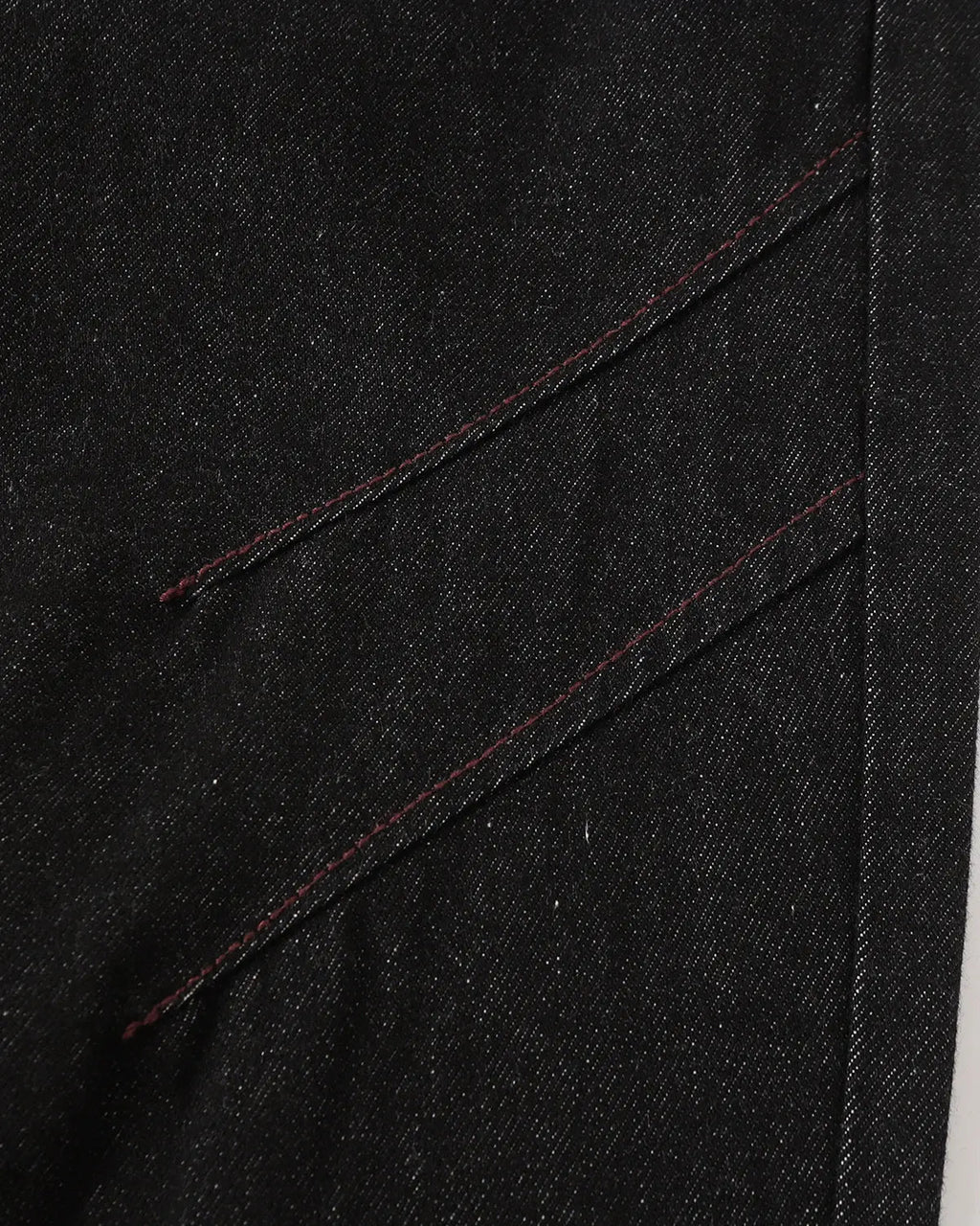 Deconstructed raw denim bootcut jeans by INFLATION with visible stitching details and distressed raw hem for streetwear style.