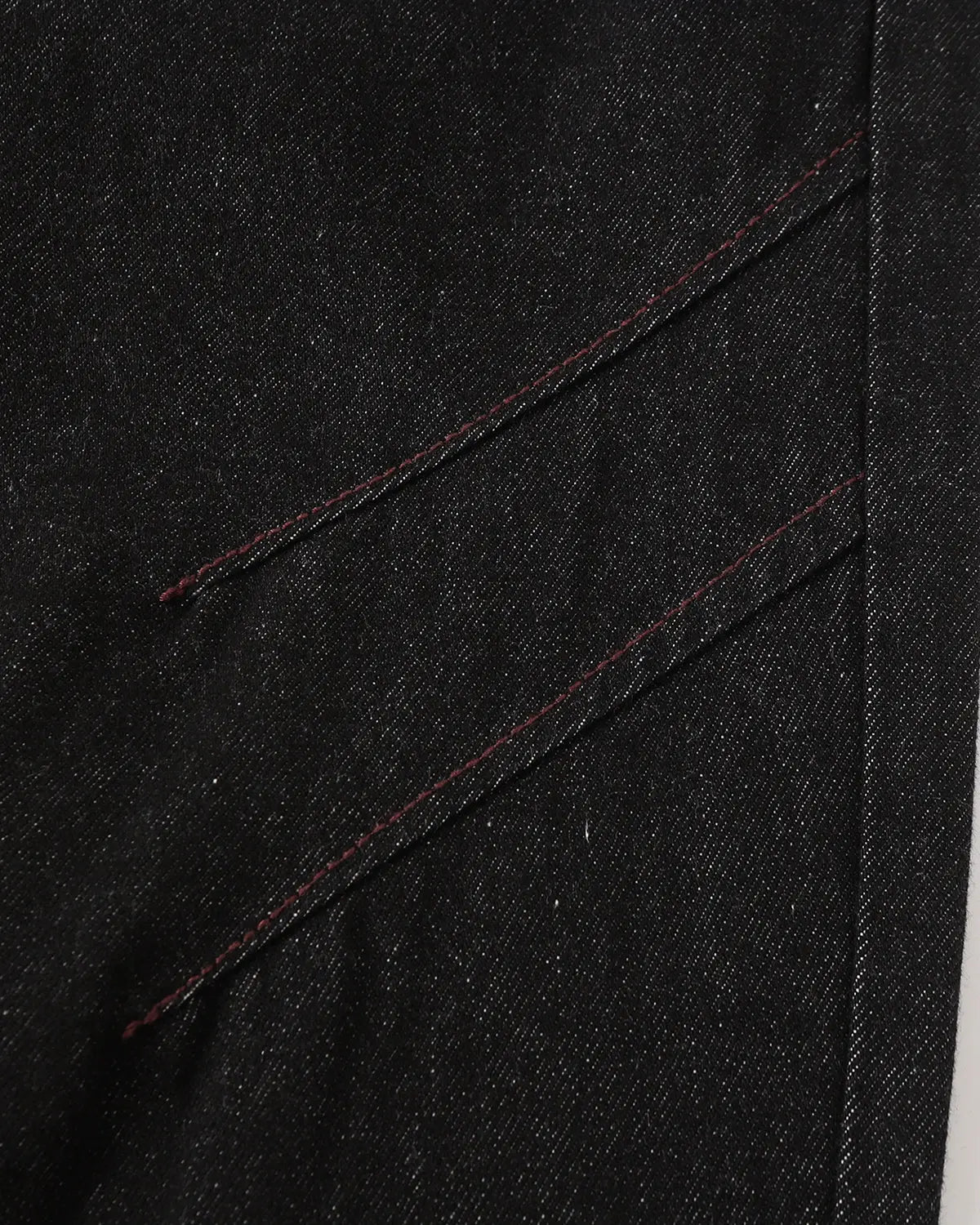 Deconstructed raw denim bootcut jeans by INFLATION with visible stitching details and distressed raw hem for streetwear style.