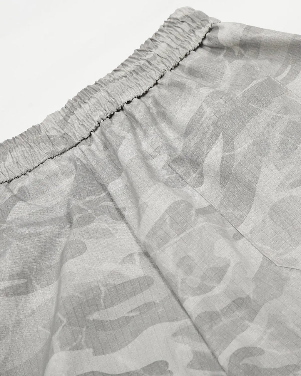 Camouflage cargo barrel pants by INFLATION featuring a relaxed fit, multiple pockets, and streetwear style in a green and brown camouflage pattern.
