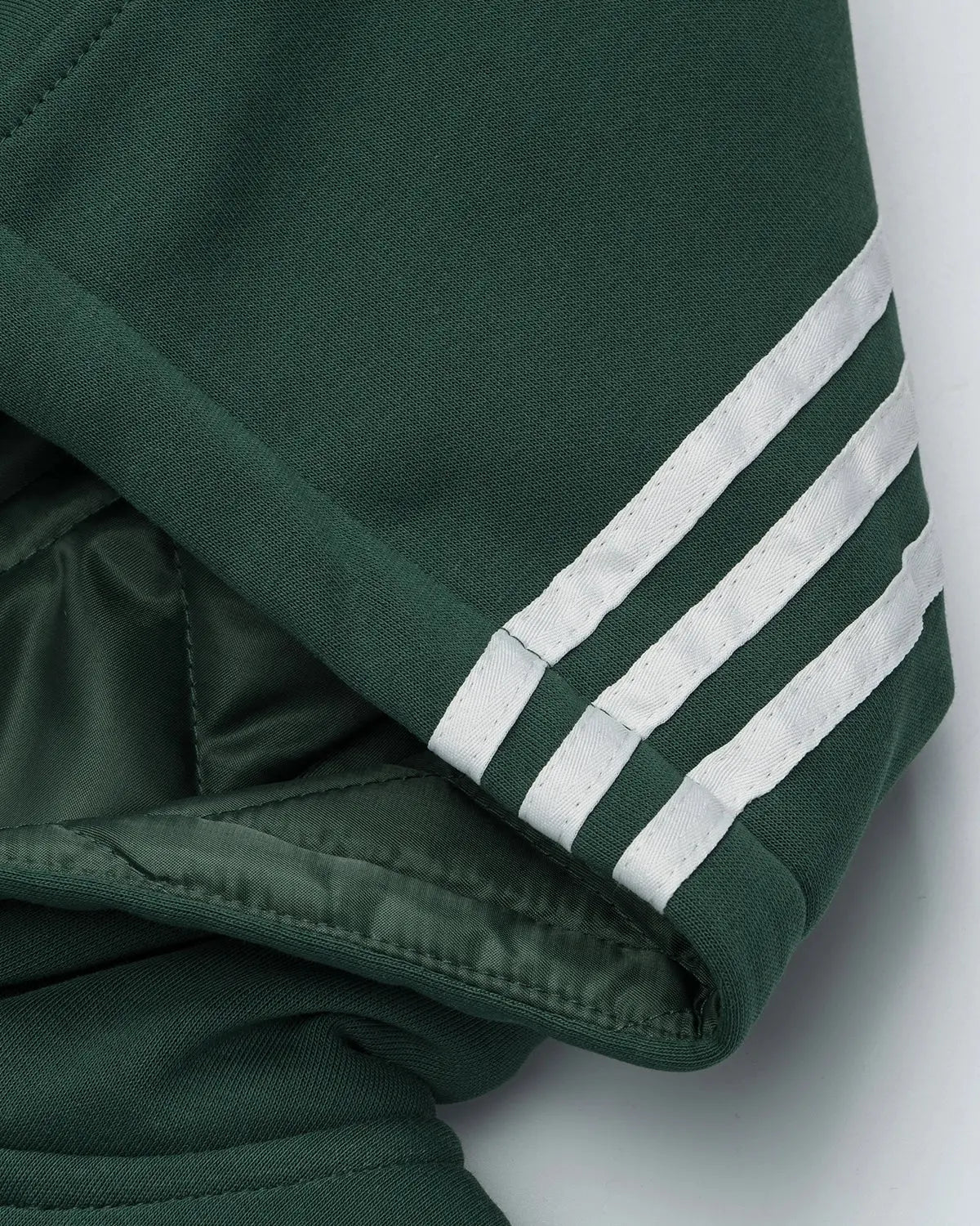 Black gothic striped hooded bomber jacket by INFLATION with bold vertical stripes and a casual streetwear style.