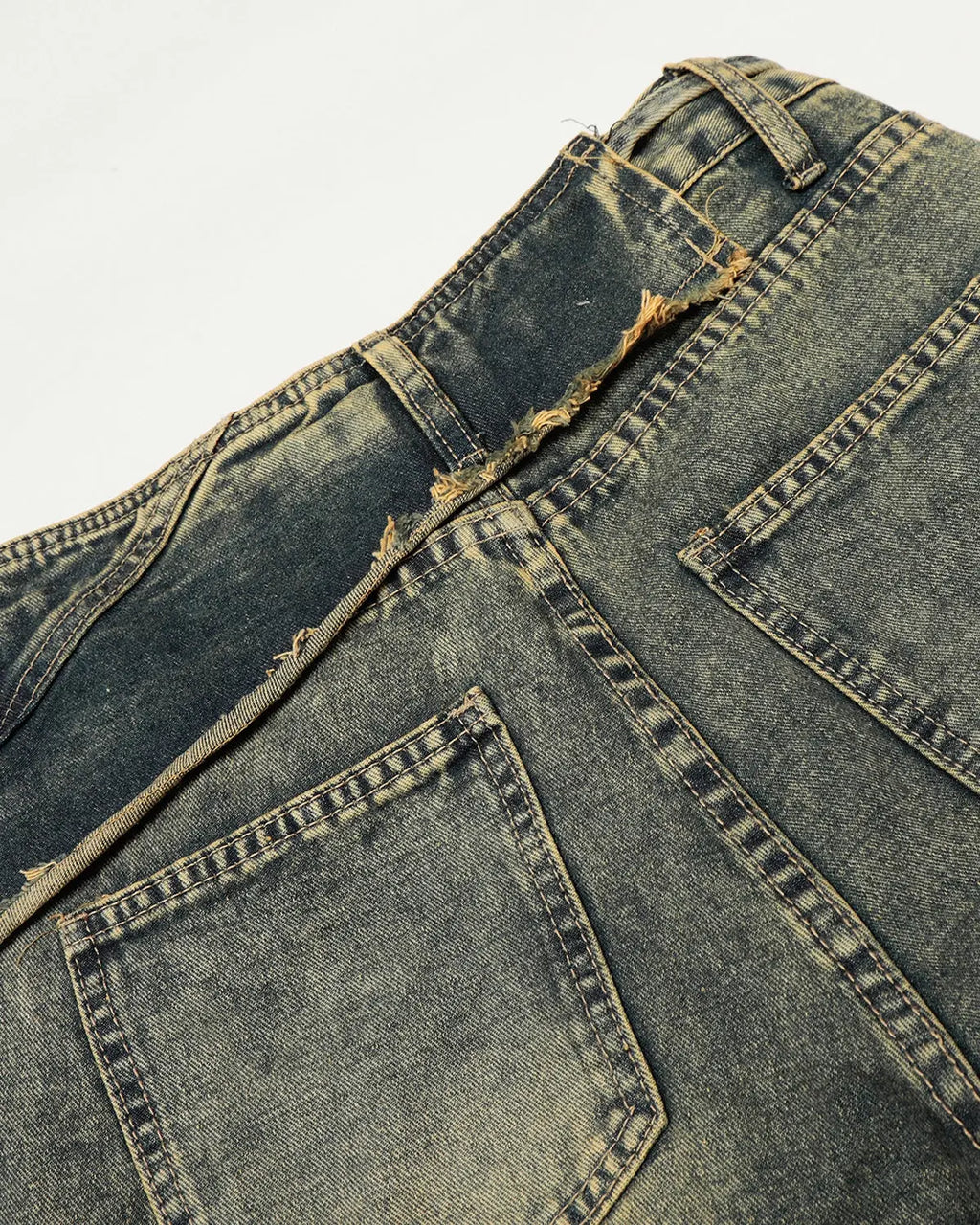 Distressed washed wide-leg denim jeans by INFLATION, showing a relaxed fit with frayed edges and a faded, vintage look.