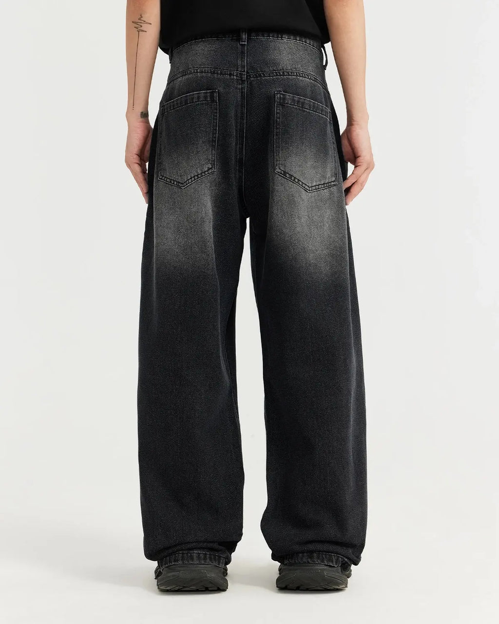 Black washed baggy jeans from Flation Streetwear, showing relaxed fit and distressed denim texture.