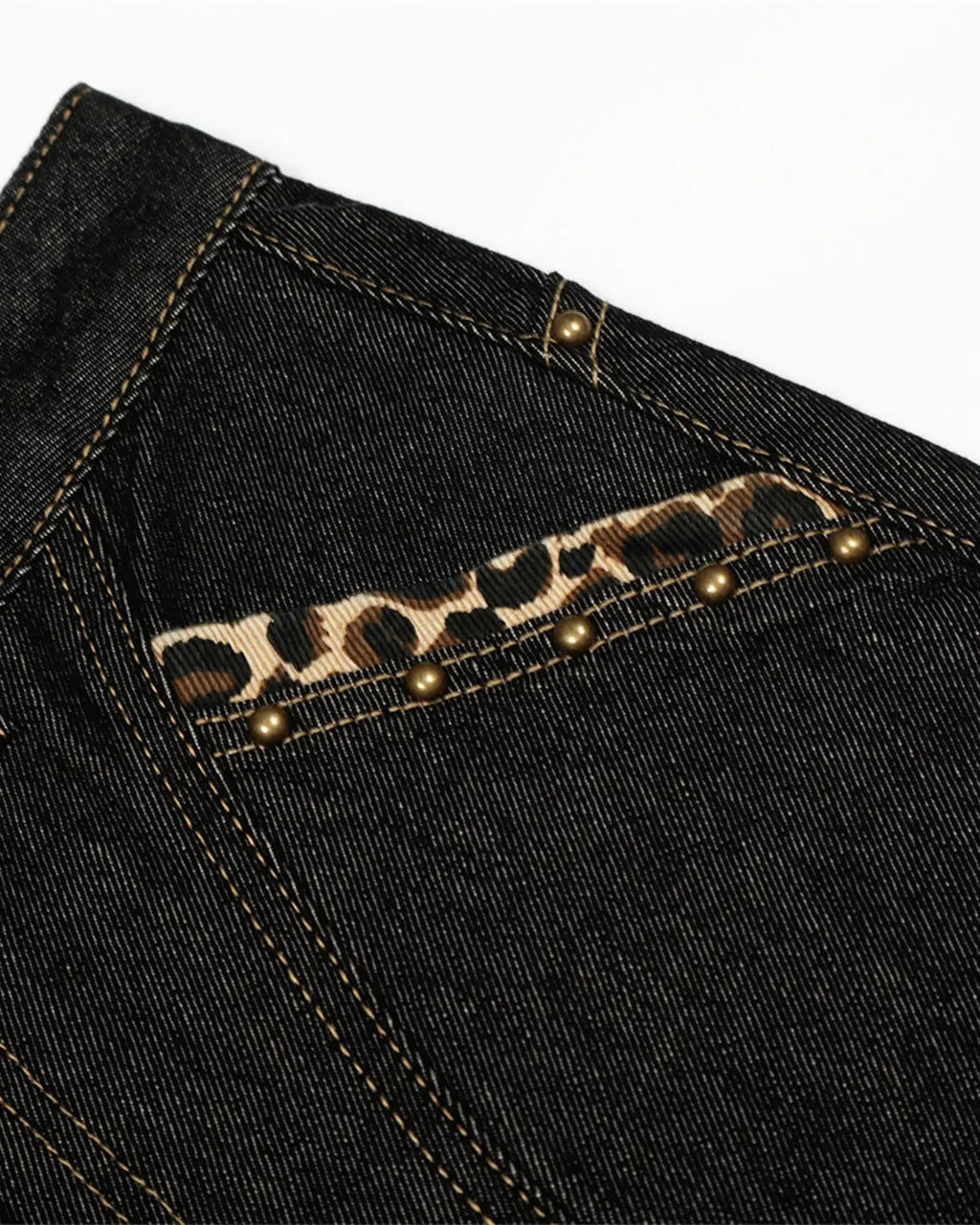 Gothic cross embroidery on black barrel jeans by INFLATION, featuring streetwear style with detailed stitching.