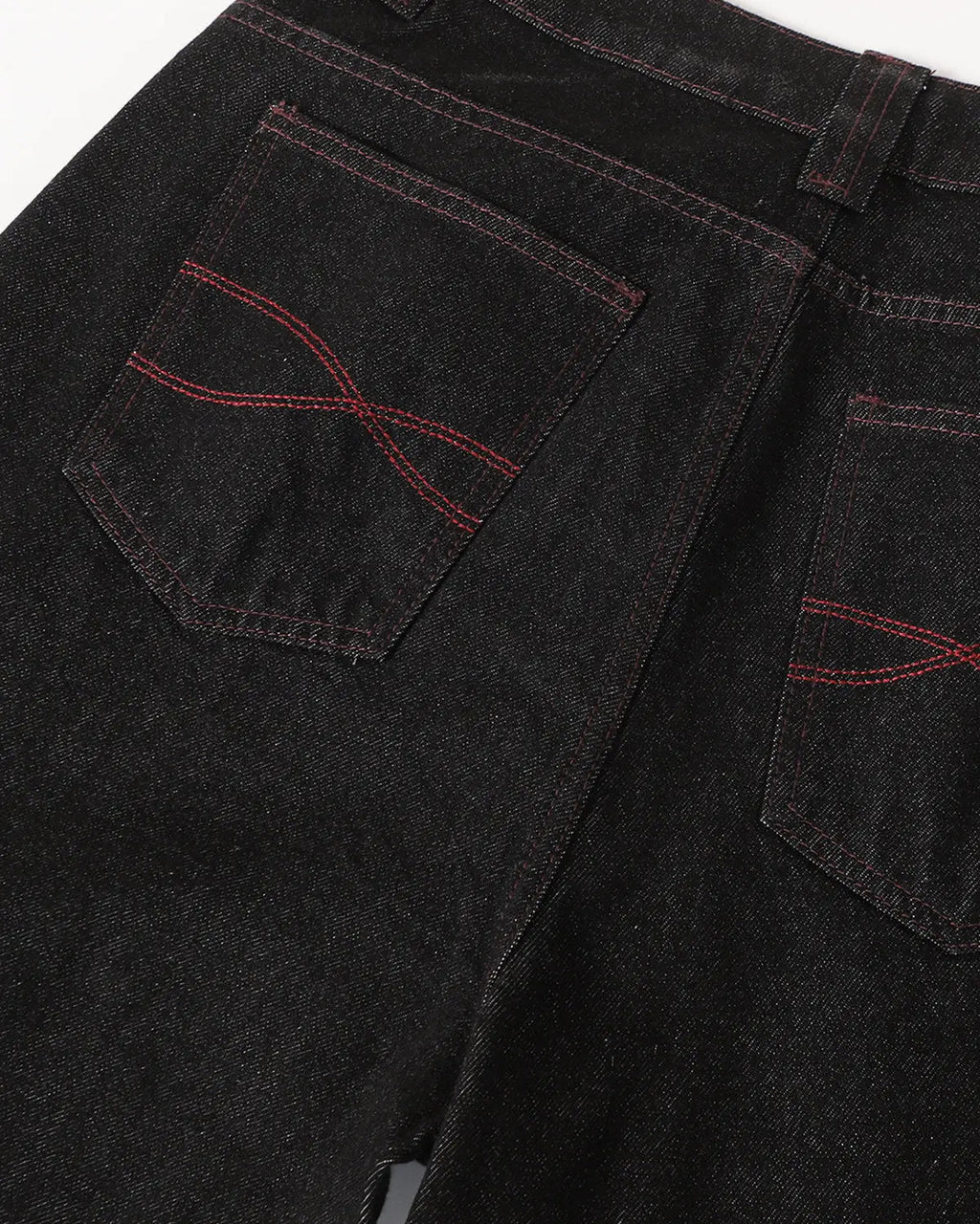 Deconstructed raw denim bootcut jeans from INFLATION featuring visible stitching and distressed details on a model.