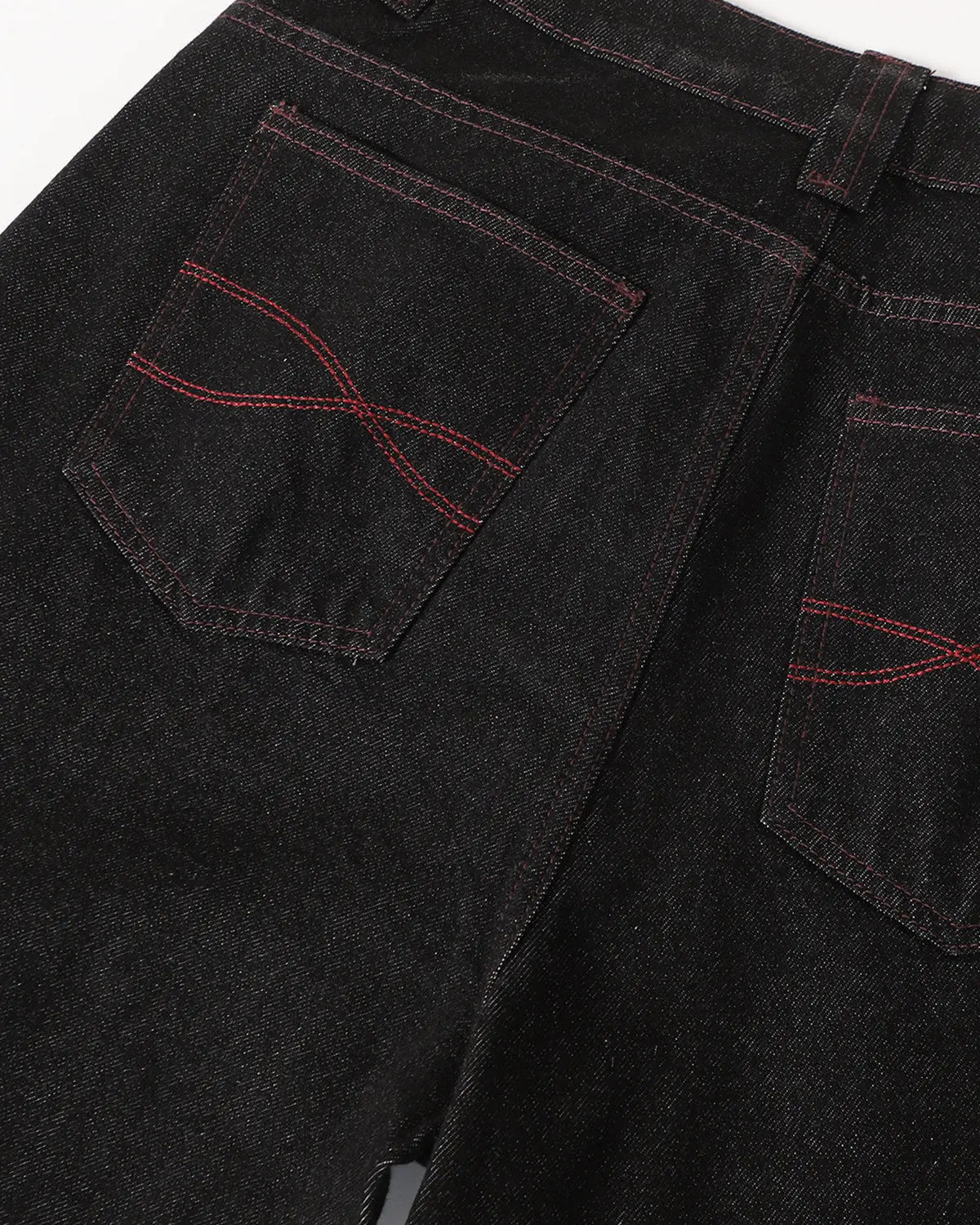 Deconstructed raw denim bootcut jeans from INFLATION featuring visible stitching and distressed details on a model.