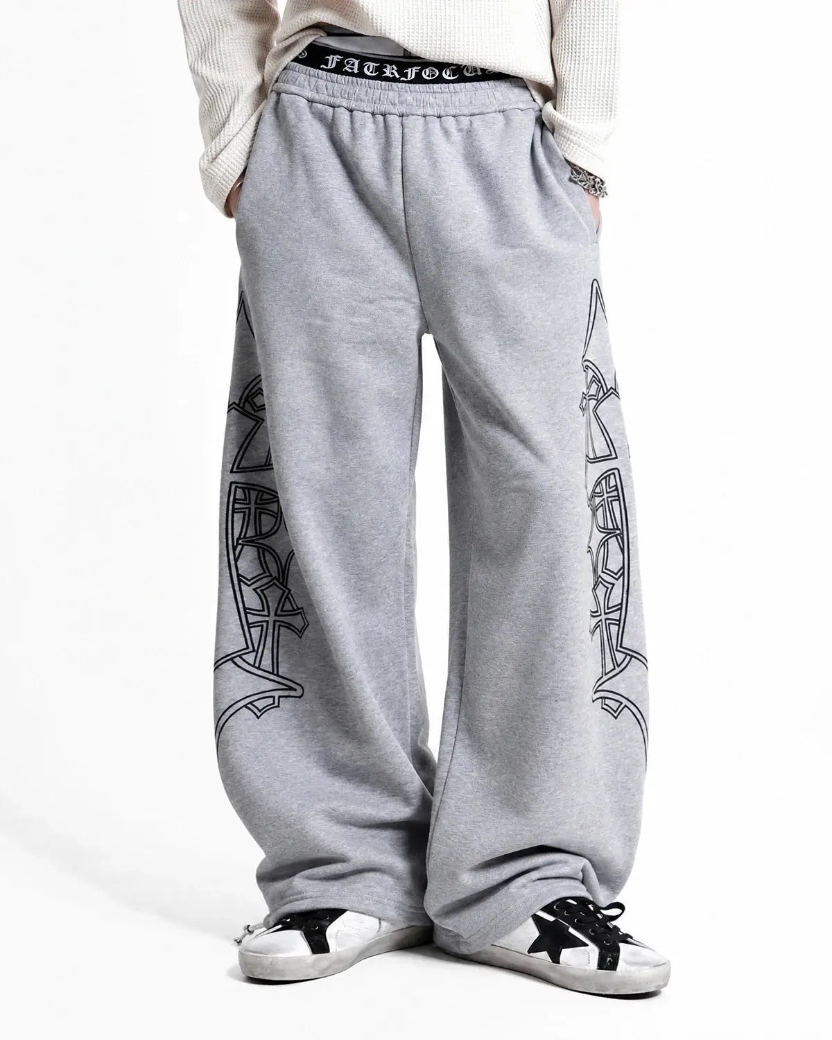 Gothic layered baggy sweatpants by INFLATION featuring a loose fit, dark fabric, and streetwear style with layered design details.