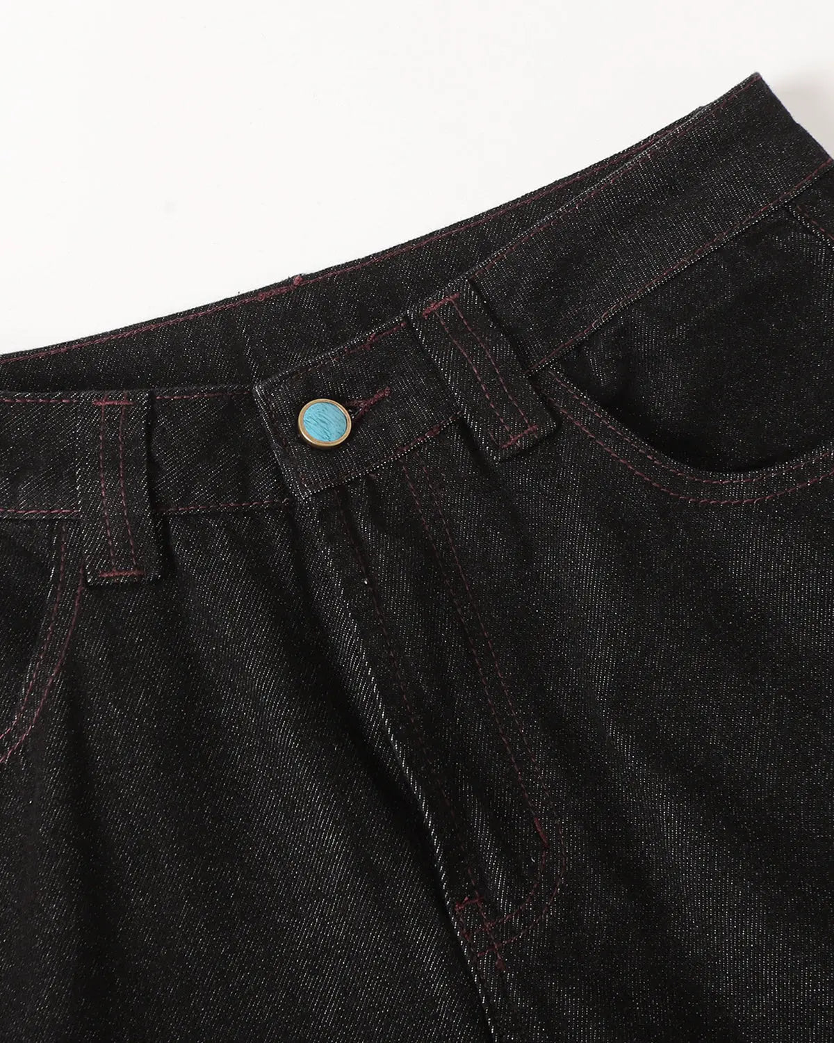 Deconstructed raw bootcut jeans by INFLATION featuring visible stitching details and distressed raw denim texture.