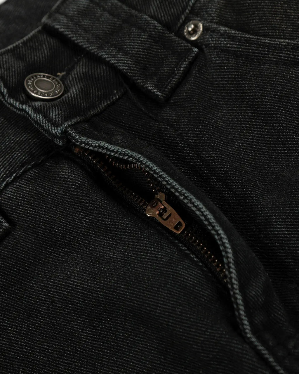 Black patchwork barrel jeans by INFLATION with distressed details and unique stitching, styled on a mannequin.