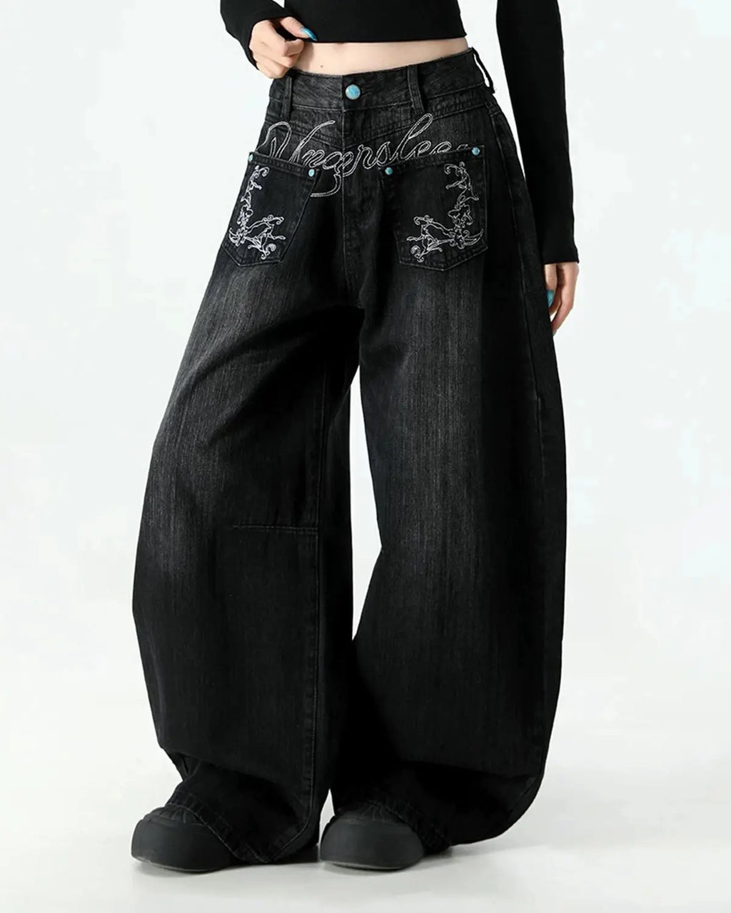 Graphic embroidered washed barrel jeans by INFLATION, styled as casual streetwear pants with distressed denim and unique embroidered details.
