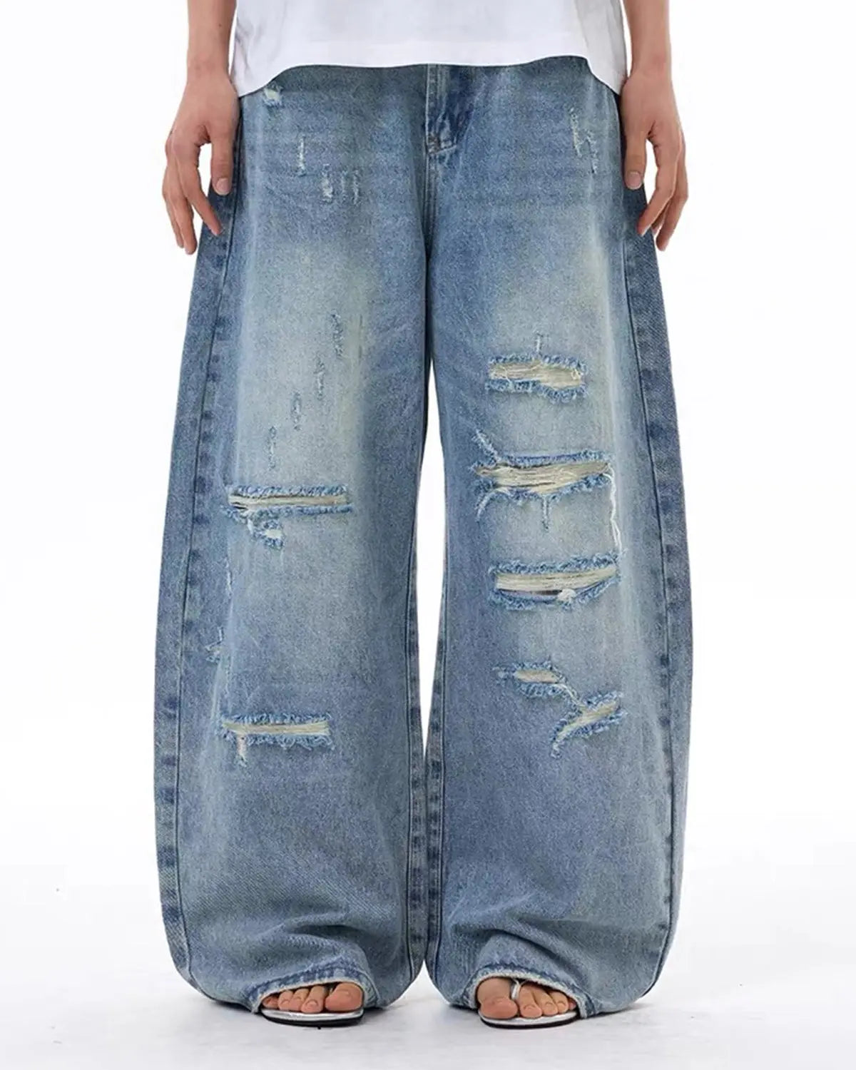Vintage wash distressed baggy jeans by INFLATION with a relaxed fit and rugged style, shown on a model.