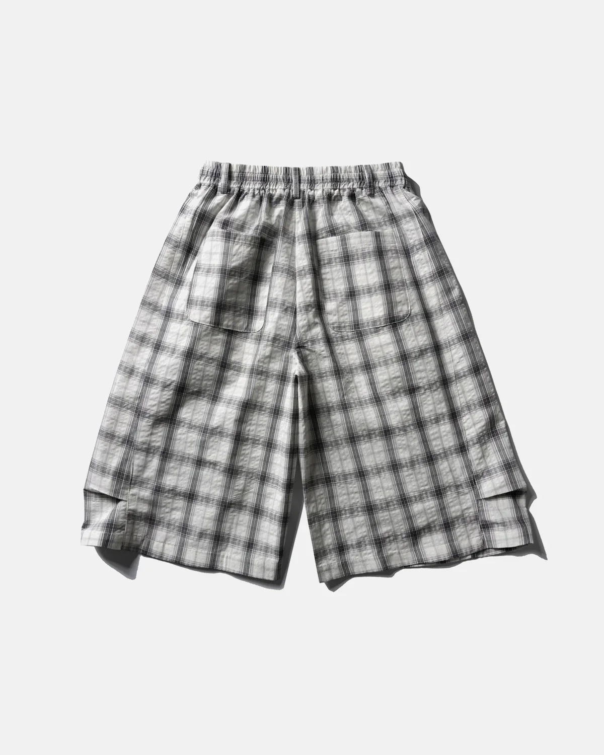 Inflation brand plaid longline casual shorts with a relaxed fit and blue, red, and white checkered pattern on lightweight fabric.
