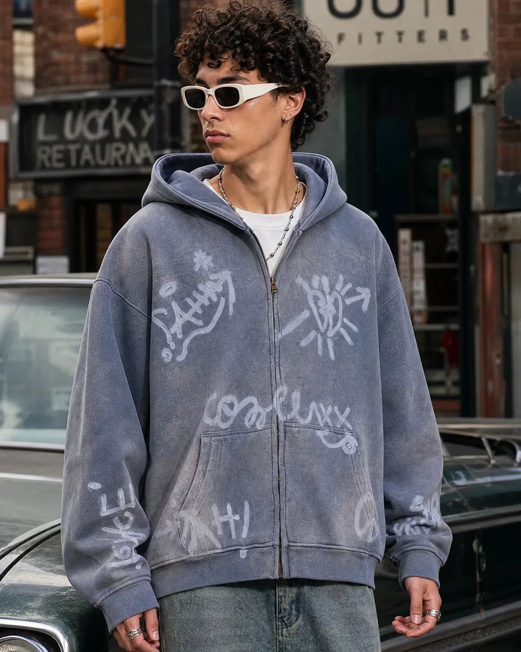 Flation graffiti washed zip-up hoodie featuring a colorful graffiti design and a casual, relaxed fit on a model.