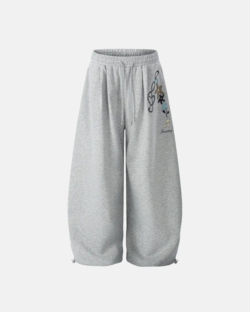 Inflation Streetwear Applique Baggy Sweatpants in black with large side pockets and relaxed fit, featuring bold applique details.