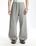 INFLATION grey baggy sweatpants with a relaxed fit, featuring an elastic waistband and casual style, shown on a model.