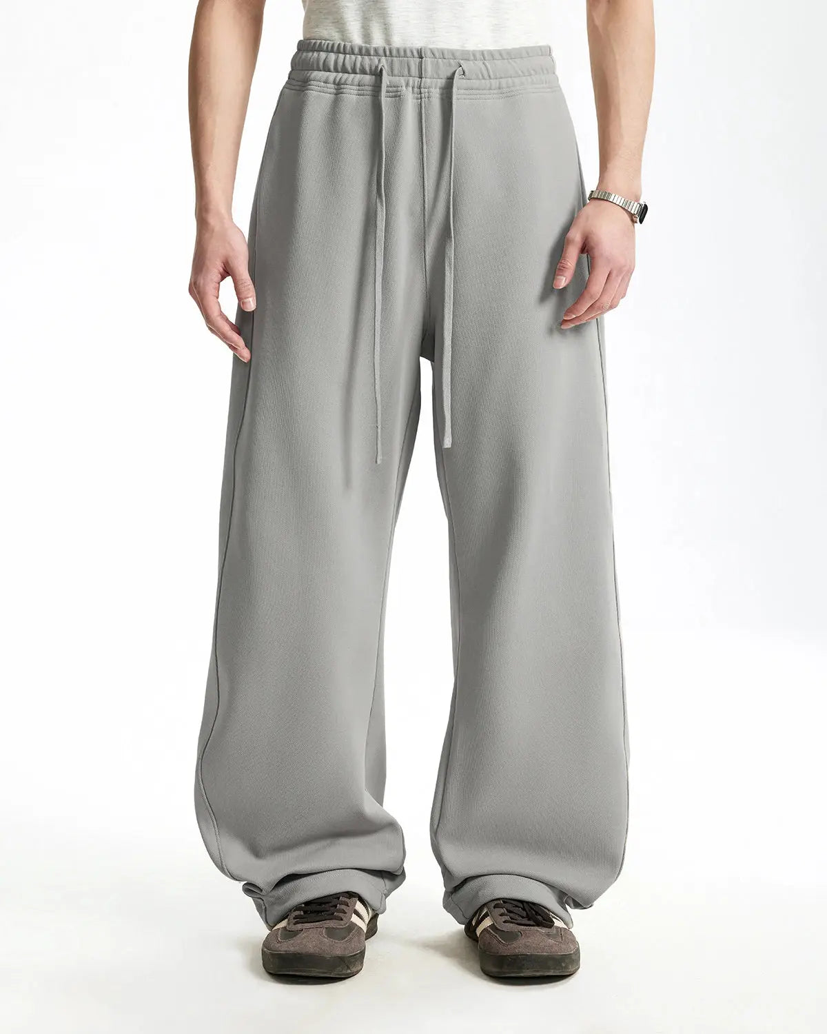 INFLATION grey baggy sweatpants with a relaxed fit, featuring an elastic waistband and casual style, shown on a model.