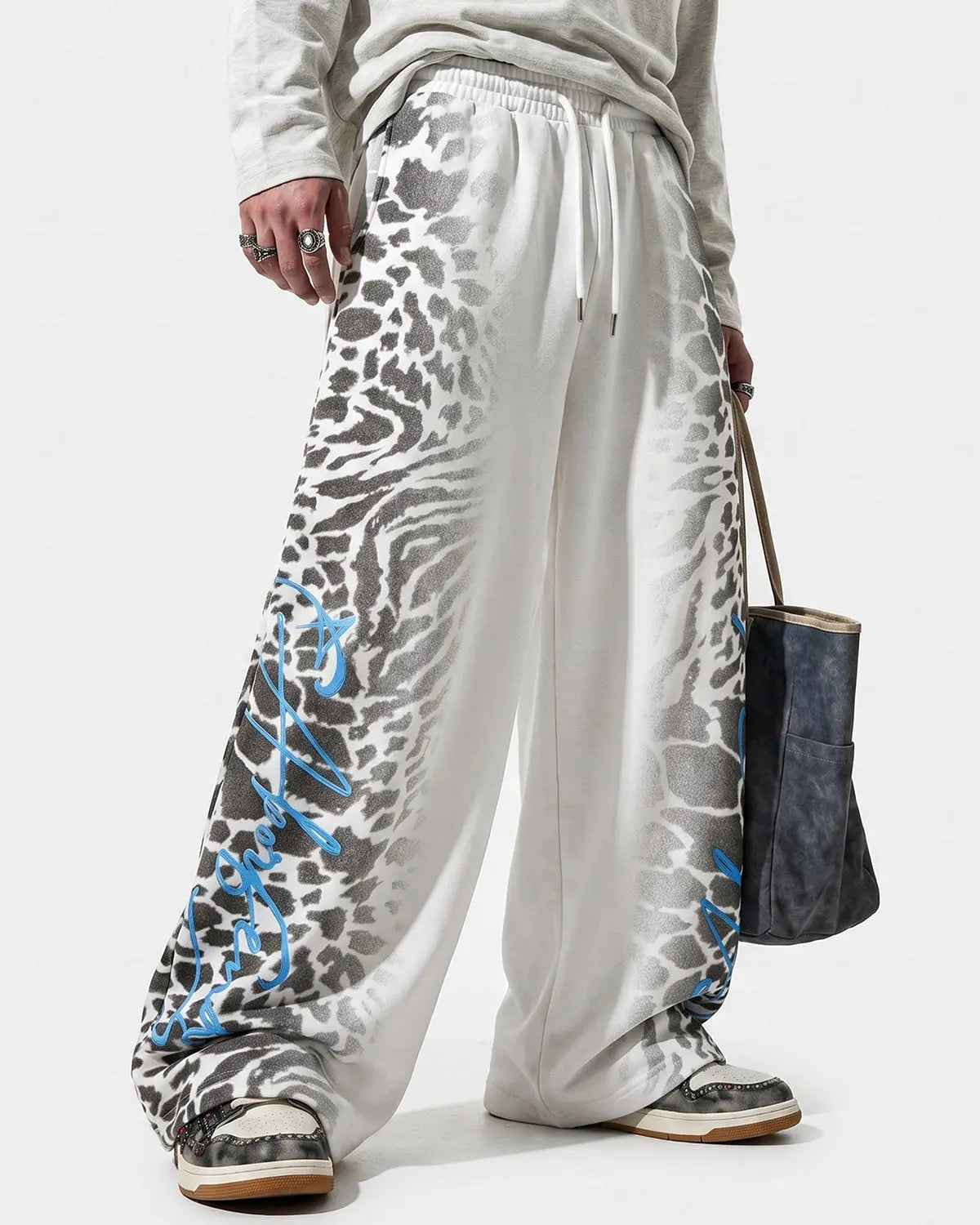 Leopard graphic barrel sweatpants by INFLATION featuring bold animal print and relaxed streetwear style.