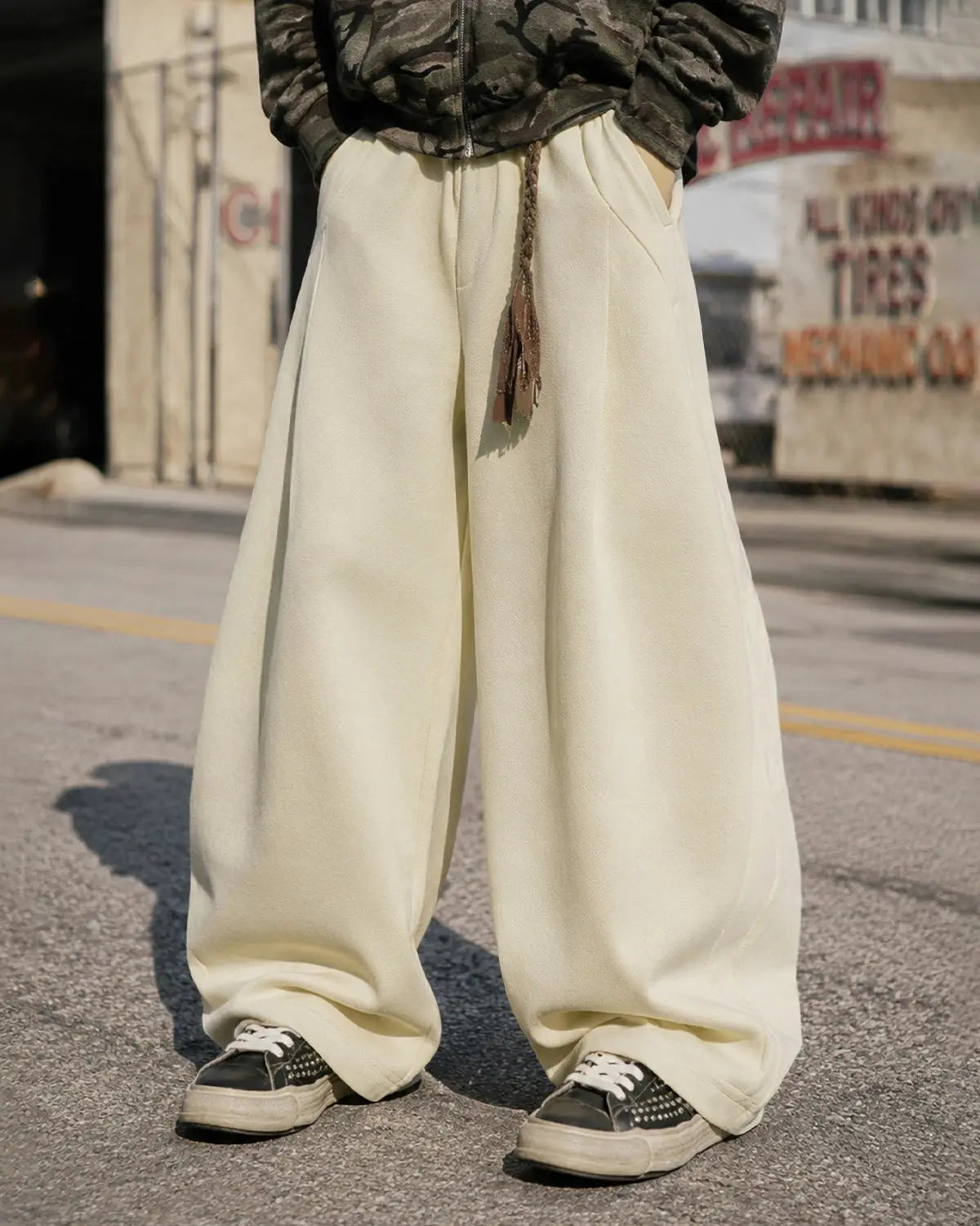 Deconstructed wide-leg sweatpants by INFLATION with layered fabric design and relaxed fit, displayed on a hanger.